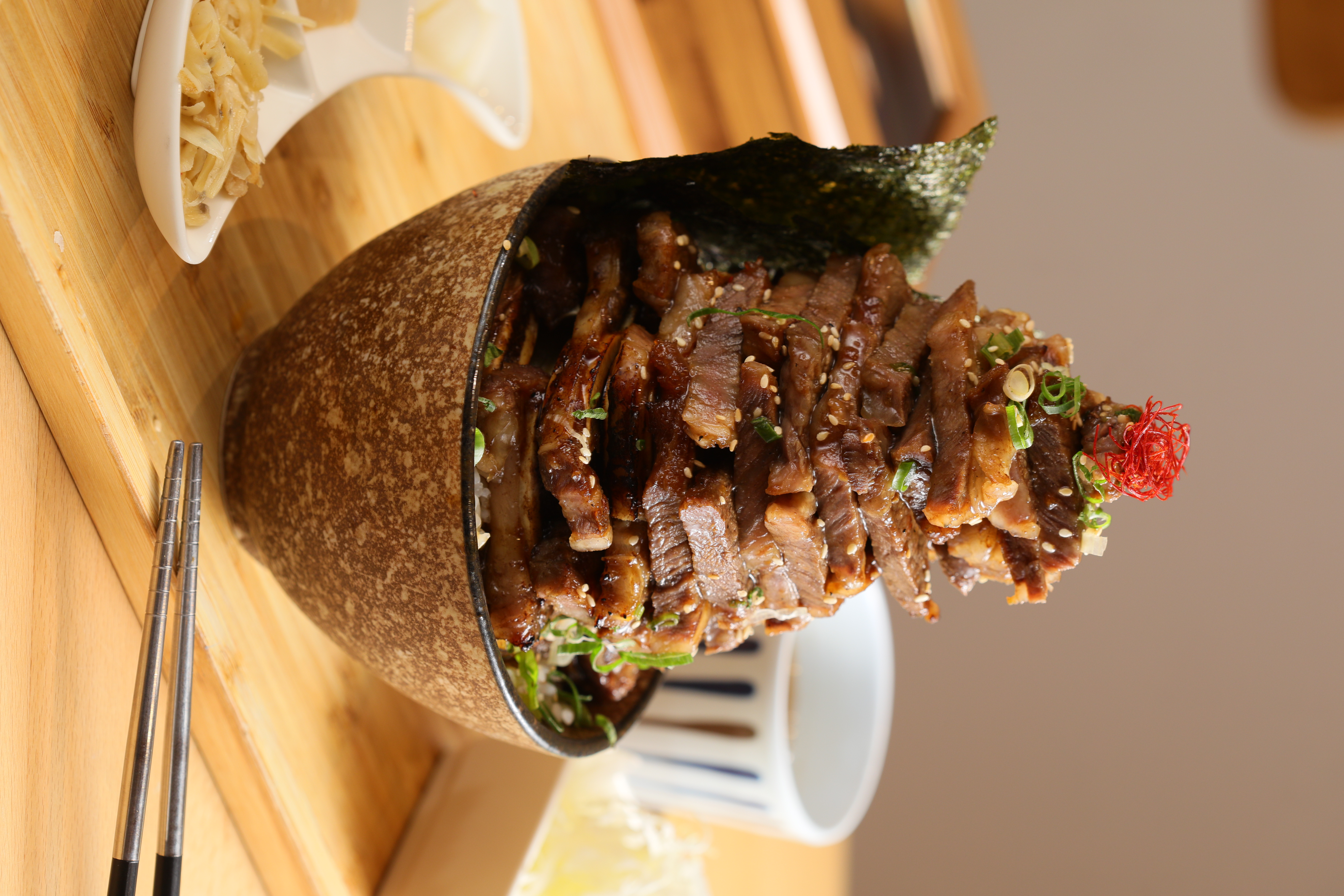 「特上帶骨牛小排丼飯定食」可選「並盛定食」或圖中的「升級肉量」，肉量足以堆成小山，份量同樣浮誇。（並盛定食480元／份，升級肉量640元／份）