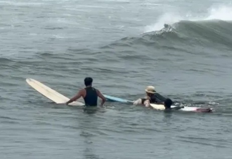 熱心衝浪客協助海巡人員搶救，將落海民眾放在衝浪板，以接力方式將人拉上岸。（第12岸巡隊提供）