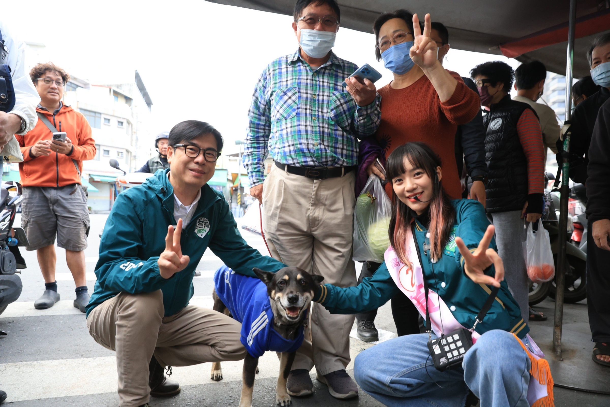 高雄市長陳其邁陪同立委候選人黃捷前往內惟市場拜票，獲婆婆媽媽爭相合影。（讀者提供）