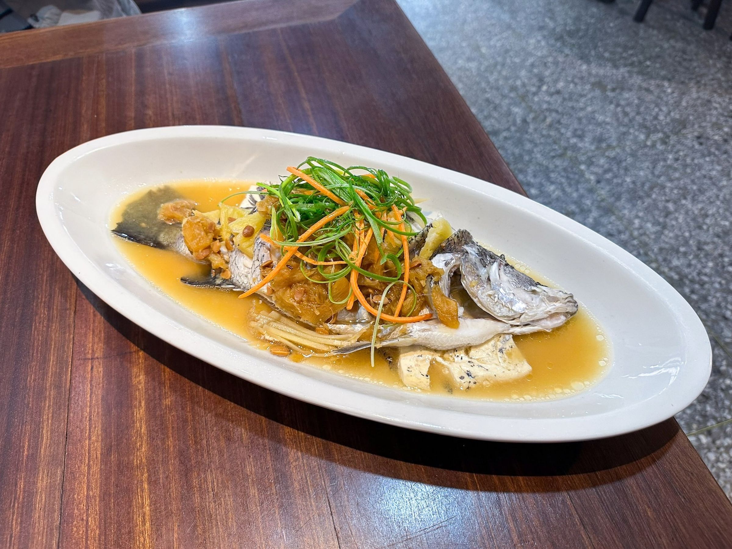 「阿爸的客家菜」的「鳳梨醬清蒸鮮魚」以高雄大樹土鳳梨加入豆粕、甘草與鹽醃漬3個月以上，醇厚鹹香碰上新鮮鳳梨酸甜，展現客家醬缸文化。（阿爸的客家菜提供）
