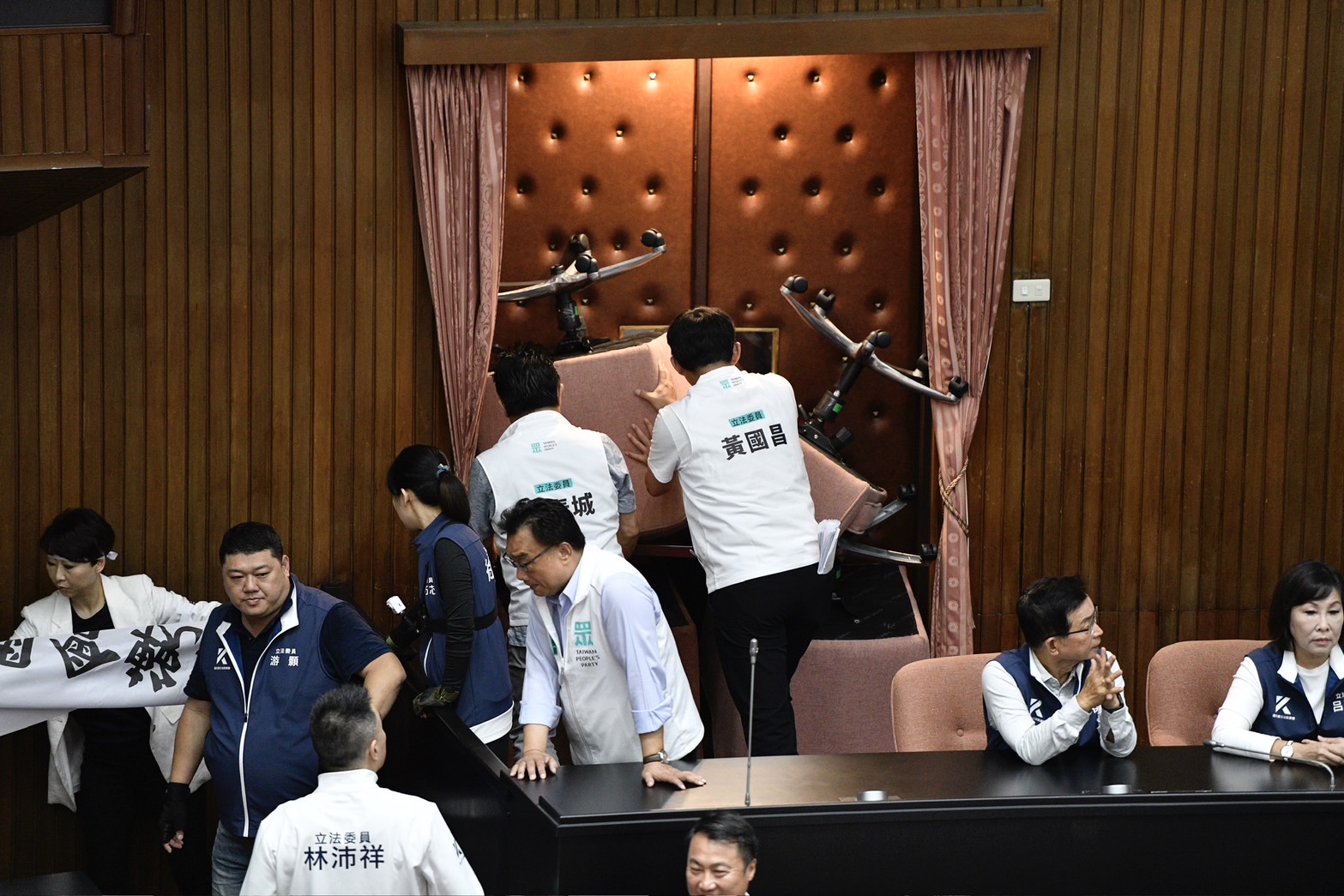 黃國昌拿議場椅子壓住大門,似乎想阻止場外綠委進入。