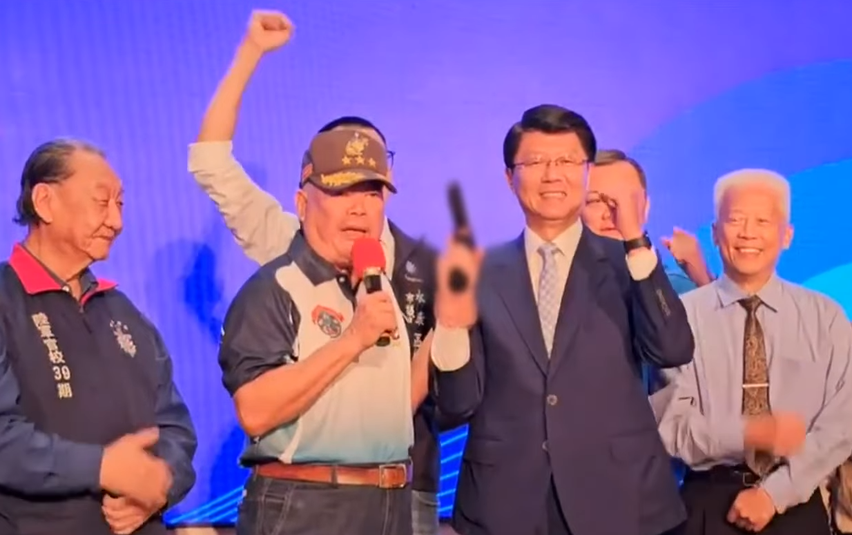 國民黨副主席季麟連贈送「手槍」給謝龍介，他還大喊要謝龍介「開槍」。（鏡新聞提供）