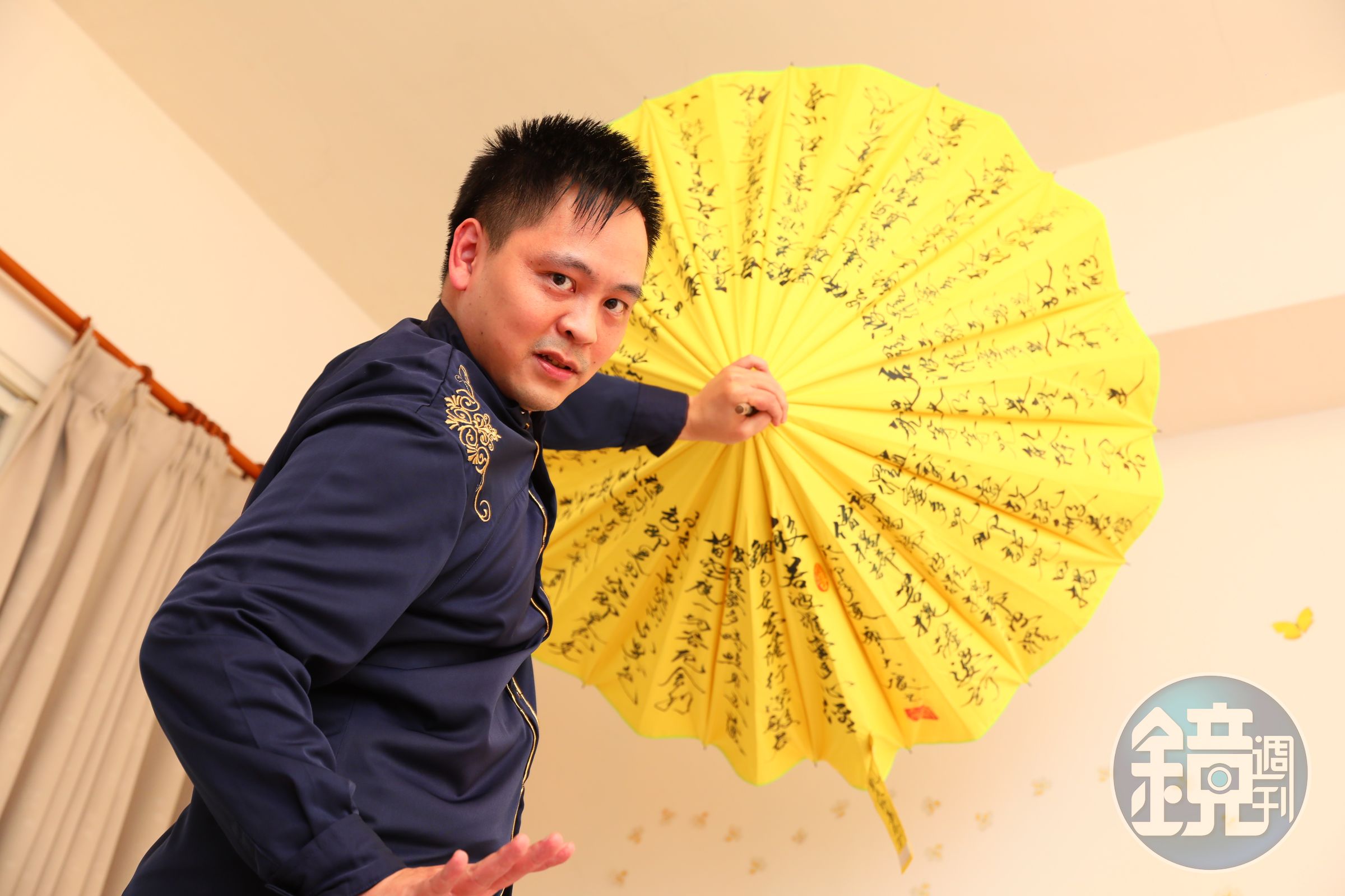 黃信凱應我們要求翻出魔術道具擺了個帥氣姿勢，他笑說，曾在表演這個從身後抽出12把雨傘的魔術時，出槌掉了一把，影片還被放上網流傳。