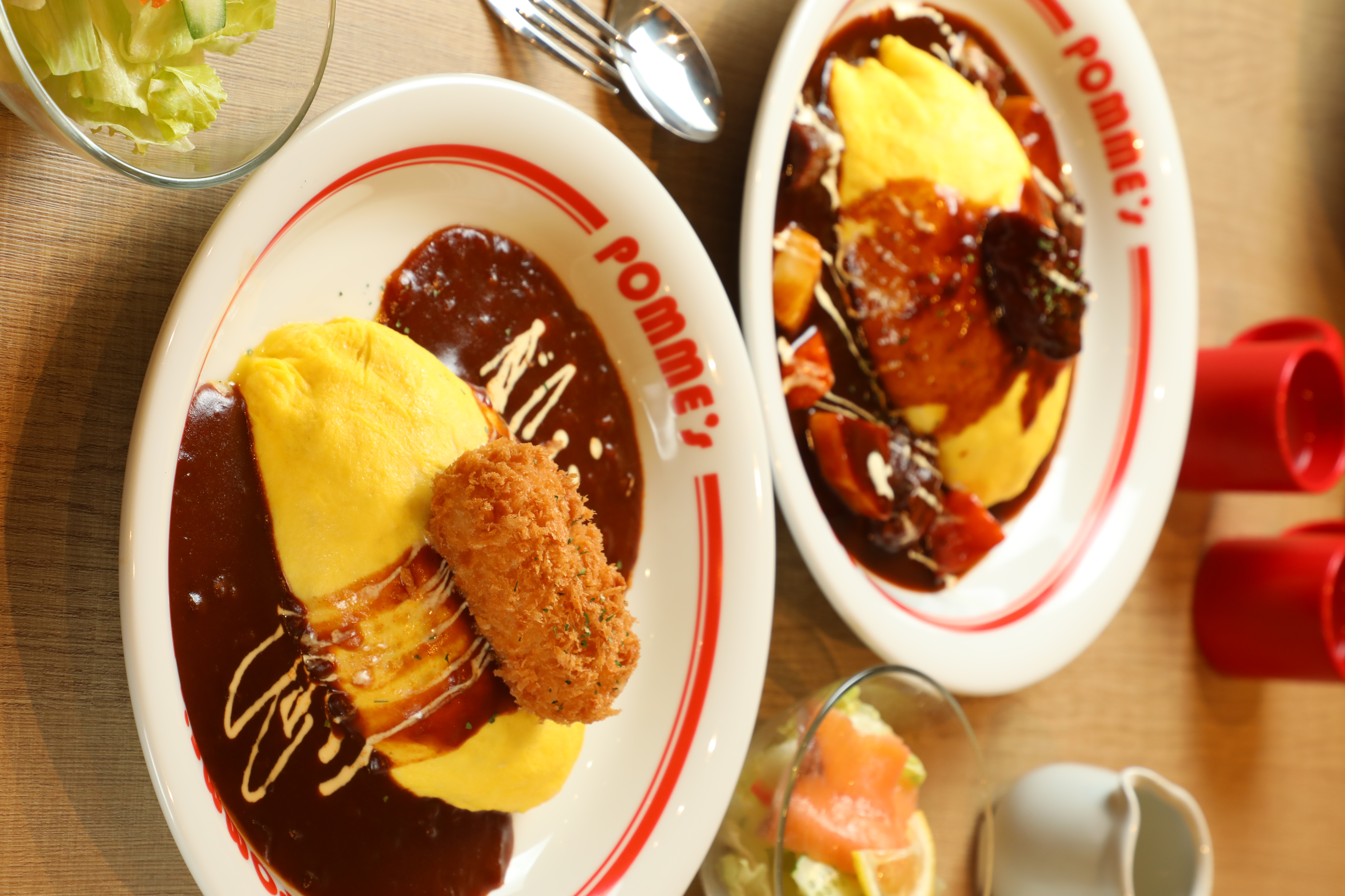 「奶油蟹肉可樂餅牛肉燴醬蛋包飯」(前,329元/S號)與「Premium燉牛肉蛋包飯」(後,499元/S號)是人氣前三名。