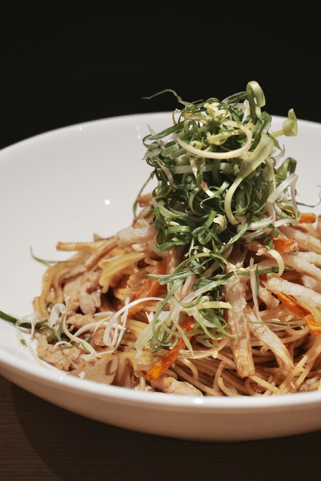 「東京風蒜辣牛蒡雞肉麵」放上大把蔥提升香度，炸牛蒡絲則大大增加了口感。（260元／份）