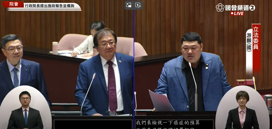 立委游顥（右）就百億癌症新藥基金財源質詢行政院長卓榮泰（左1）與衛福部長邱泰源（左2），要求衛福部盡速管治加熱菸，走私稅損讓菸捐稅挹注經費。（翻攝國會頻道YouTube頻道）