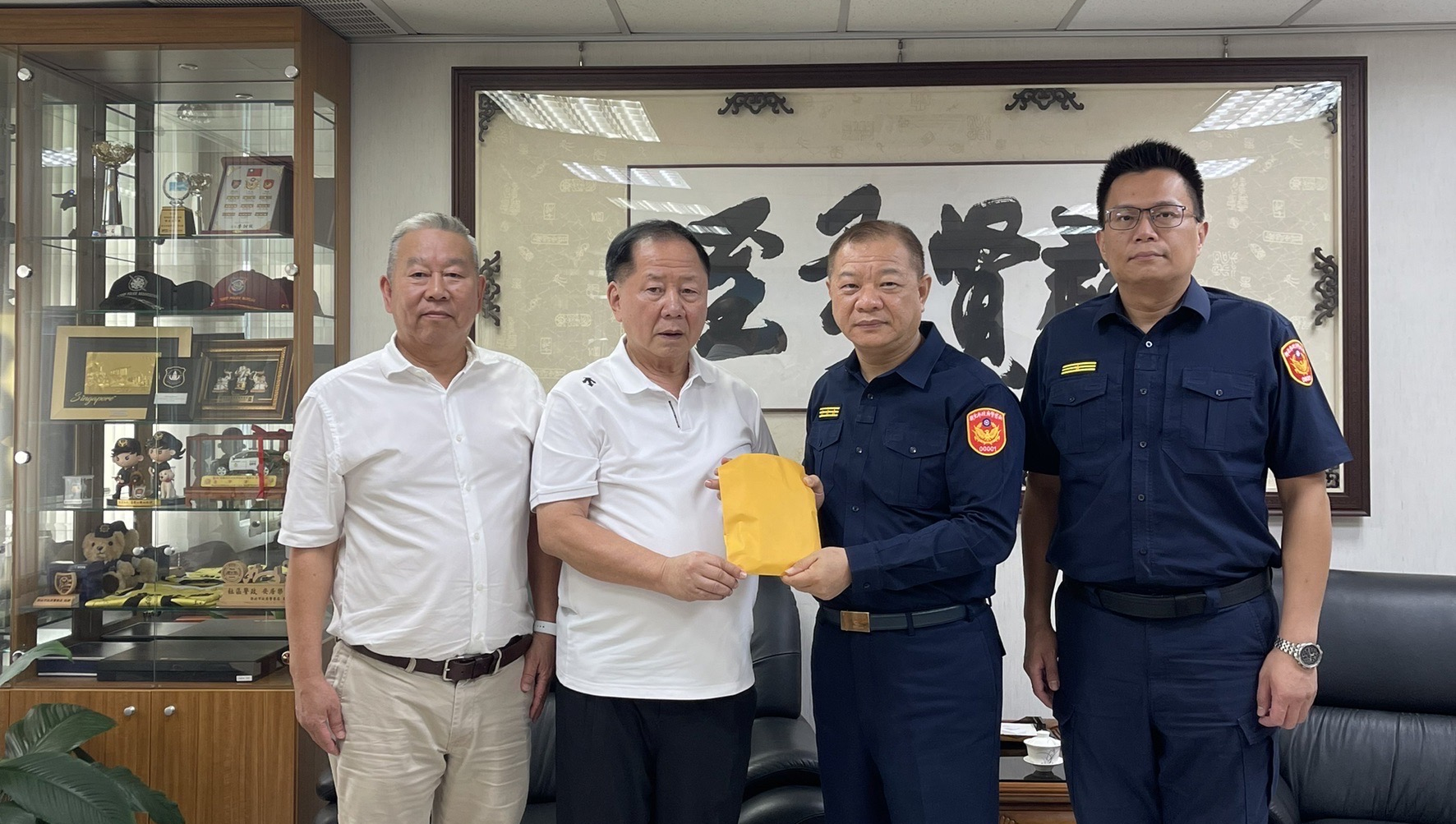 薇閣基金會李傳洪董事長（左2），在辦公室主任蔡中信（左）陪同下，將30萬元慰問金交給新北市警局長廖訓成及土城分局長陳建龍，他也承諾每個月捐助劉所長遺眷4萬元教育金直至小孩大學畢業。