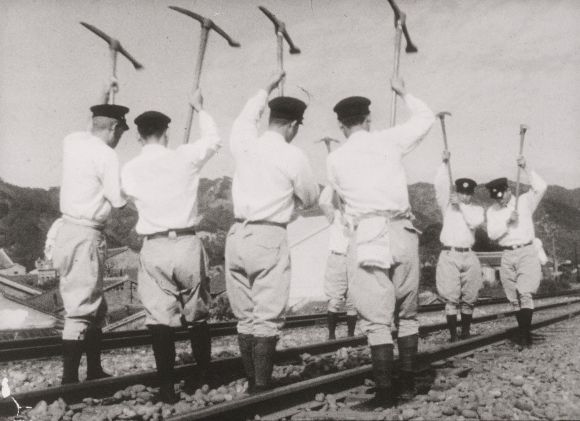《愉悅之旅》（c. 1936，台灣旅行俱樂部）道班工手持十字鎬養護軌道。（國家影視聽中心提供）