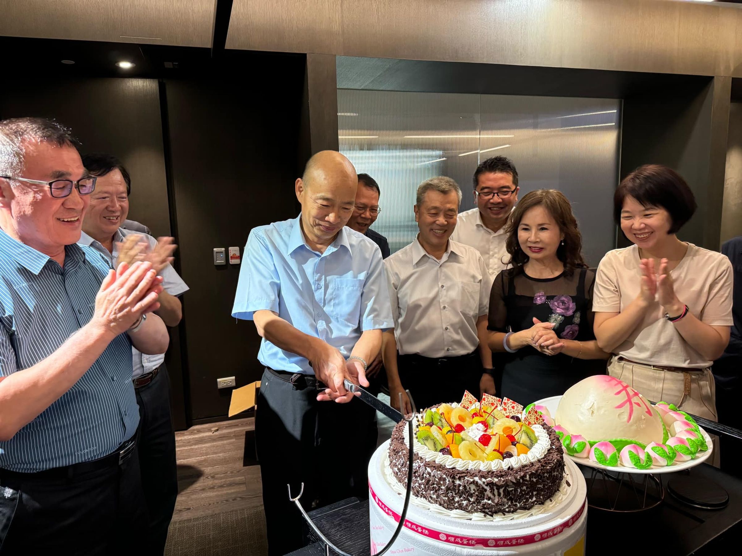 韓國瑜（中）過67歲生日，李四川（左）等人為他慶生，切蛋糕吃壽桃。（翻攝韓國瑜臉書）