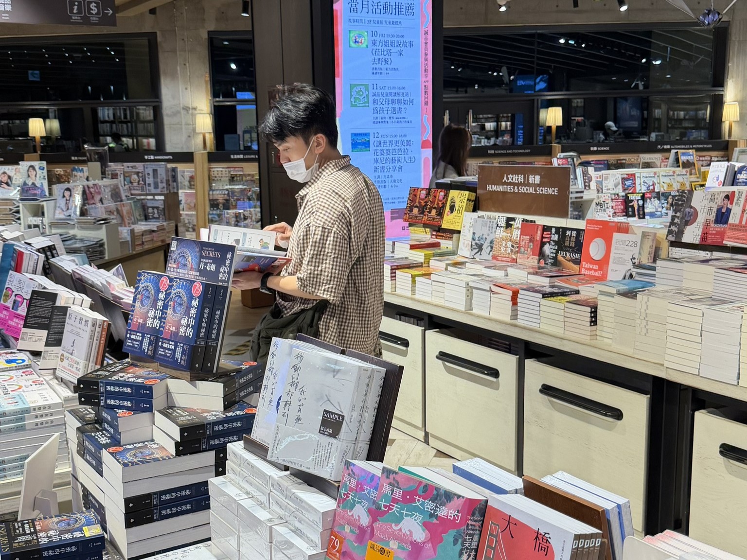 黃豪平帶著口罩、夜間現身誠品書店。（讀者提供）