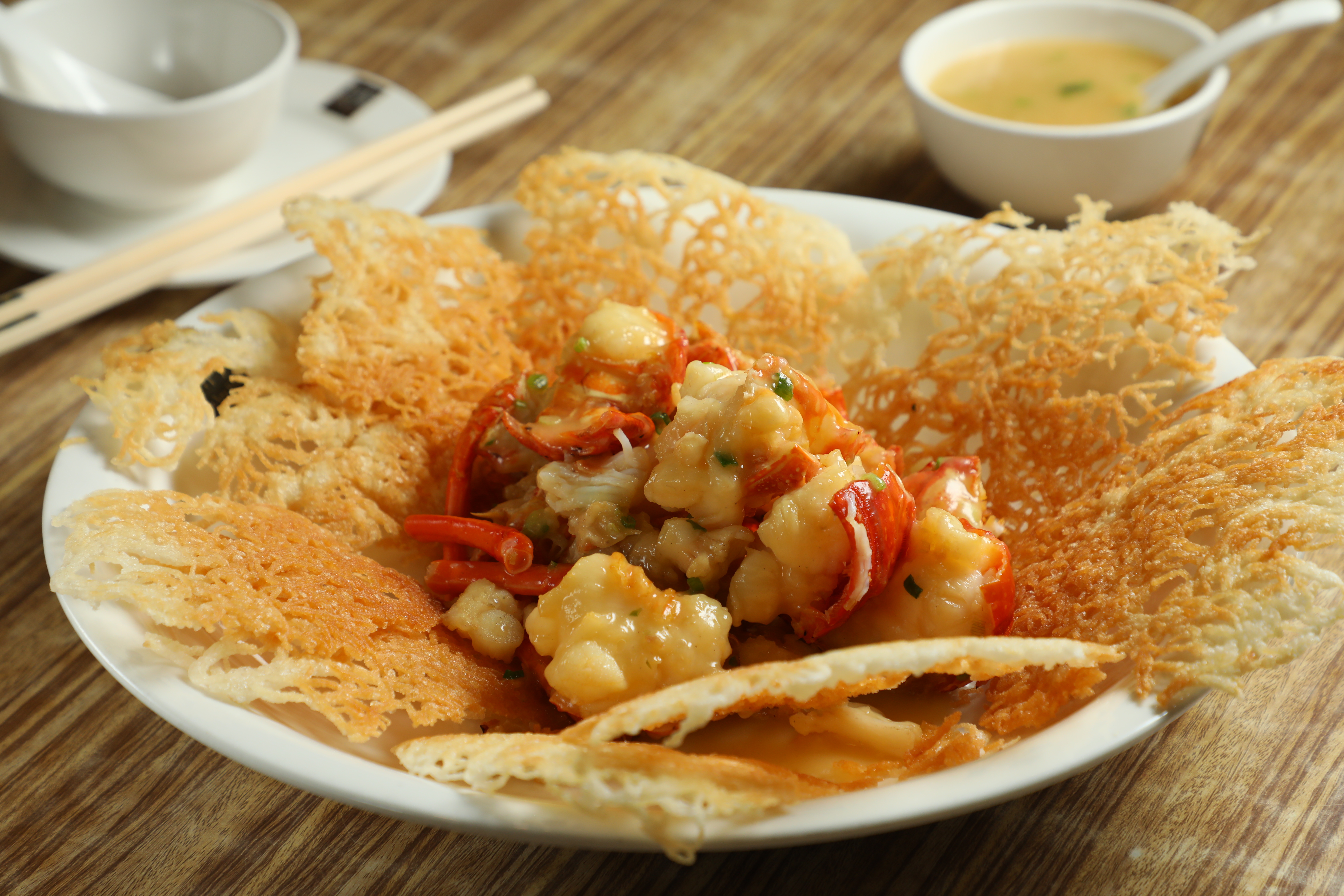 聚興家老闆兼主廚吳江橋研發的「上湯龍蝦煎米」，尺寸超大，鑊氣逼人，上桌就讓人眼前一亮。（時價，圖中約港幣1,180元／大隻，約NT$4,450）