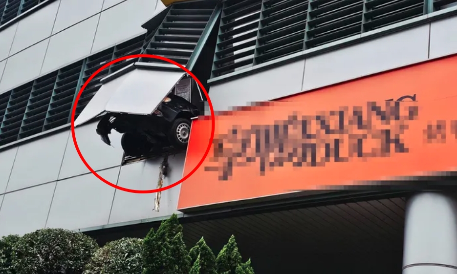 新北市板橋區台電大樓2樓停車場發生車禍，一輛轎車撞破圍牆，前輪懸掛在半空，場面險象環生。（翻攝自臉書）
