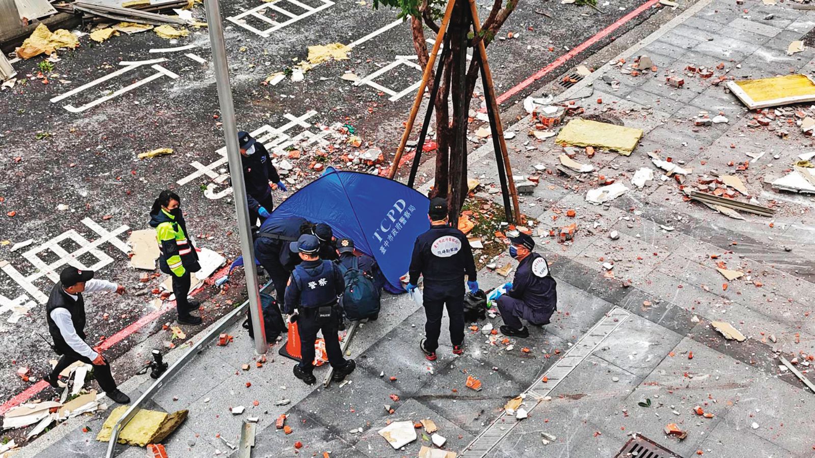 氣爆當時，行經樓下的澳門籍夫妻，不幸遭重物砸死，警方用帳篷帷幕遮蔽遺體，等候法醫相驗。（民眾提供）