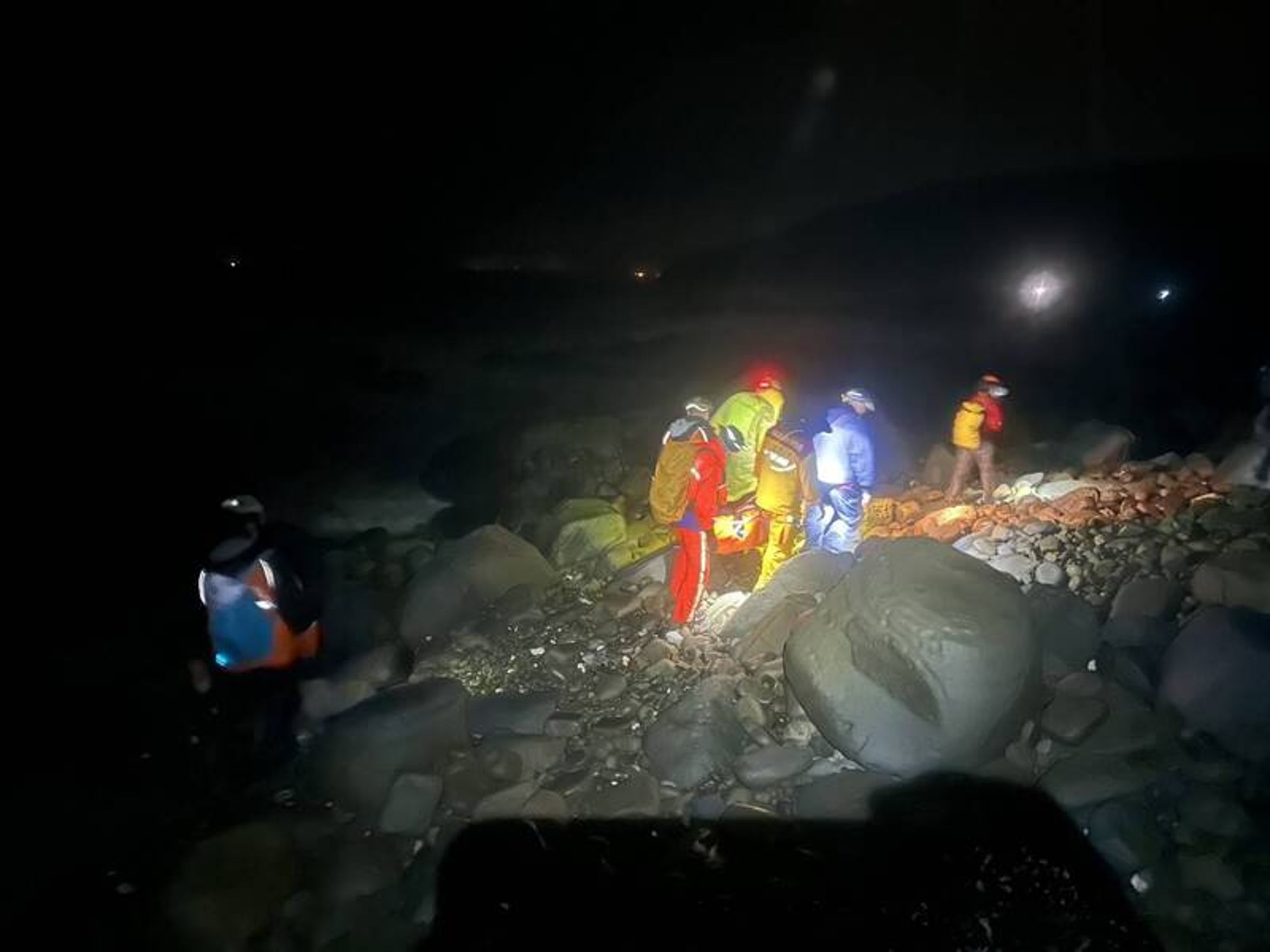 搜救人員克服山區大雷雨與陡峭地形,徹夜合力抬人數小時,將張女後送恆春旅遊醫院。(屏東消防局提供)