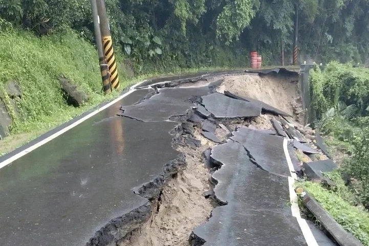路基遭雨水沖刷後滑動，柏油路面出現大範圍龜裂。（六甲區公所提供）