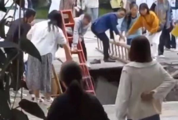中國四川省一所高中的操場8日塌陷，學生墜入地面下的濾水池，校方以梯子救援學生。（翻攝自微博）