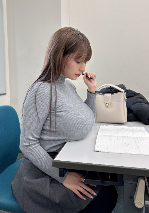 桃果明里回歸校園,在社群公開將巨乳放在教室桌上的火辣照片。(翻攝X@KimNichols50050)