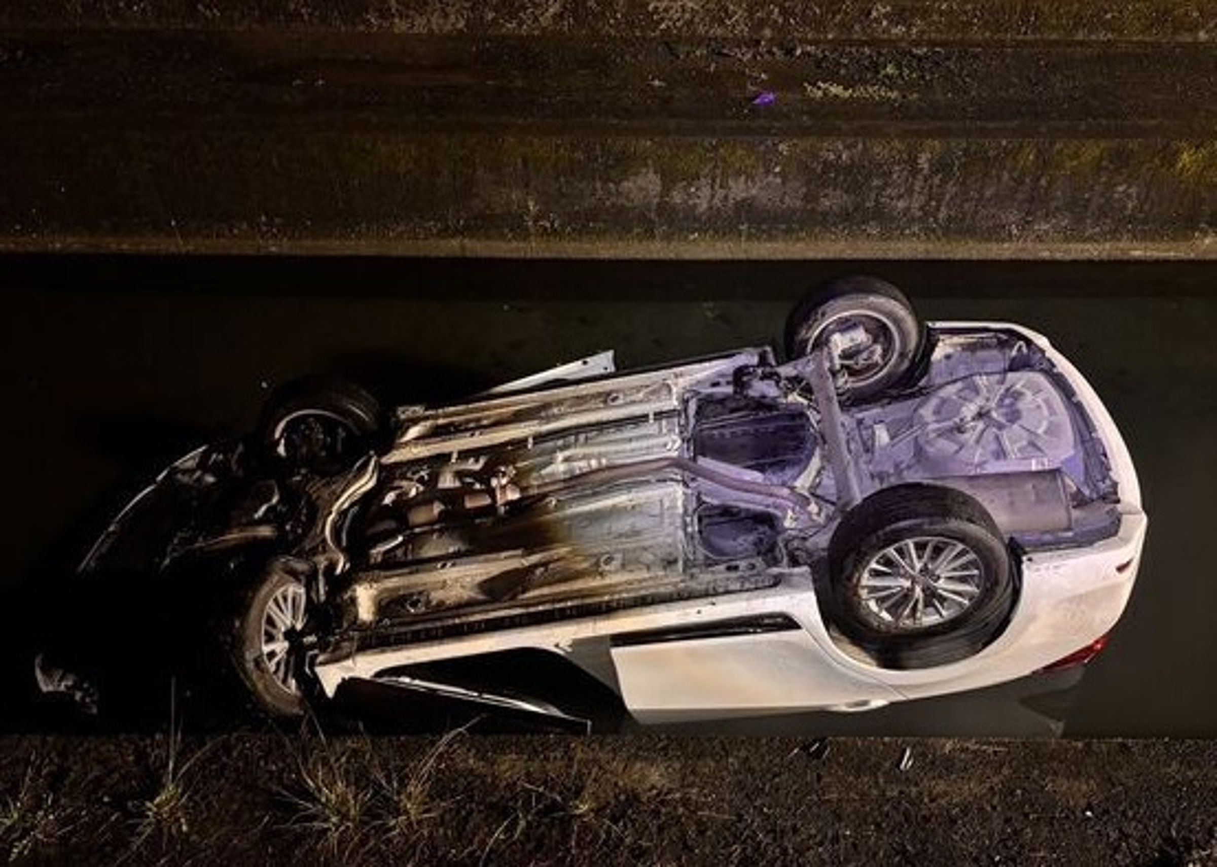 白車翻覆大排呈現四輪朝天，導致女駕駛無法脫困溺水。（翻攝畫面）