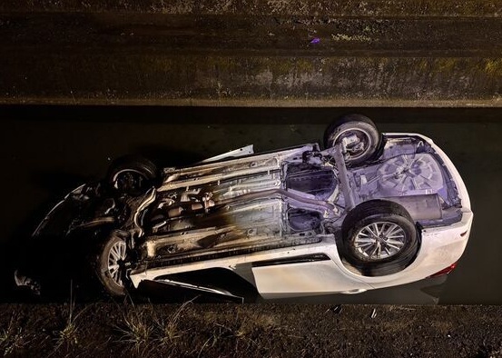 白車翻覆大排呈現四輪朝天，導致女駕駛無法脫困溺水。（翻攝畫面）