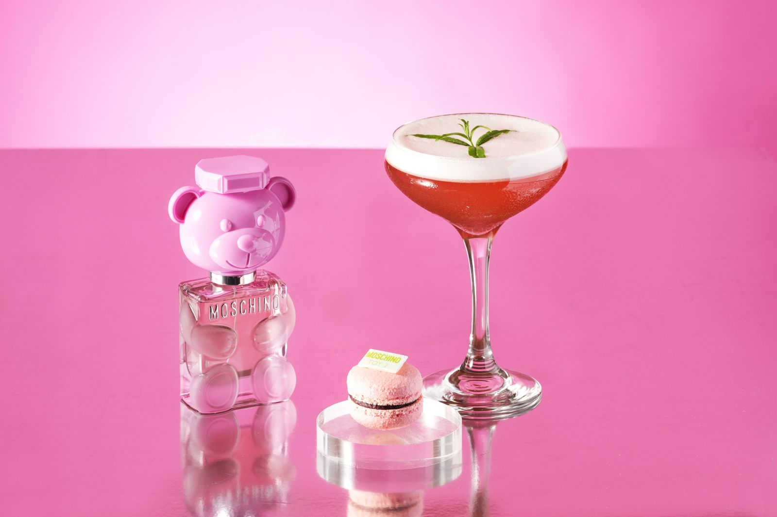 主廚以「黑醋栗甘納許馬卡龍」(左)呼應青春洋溢的MOSCHINO PARFUM「泡泡熊女性淡香水」瓶身,搭配女孩們難以抗拒的水蜜桃果香風味調酒「Bear Bubble」(右)。(台北W飯店提供)