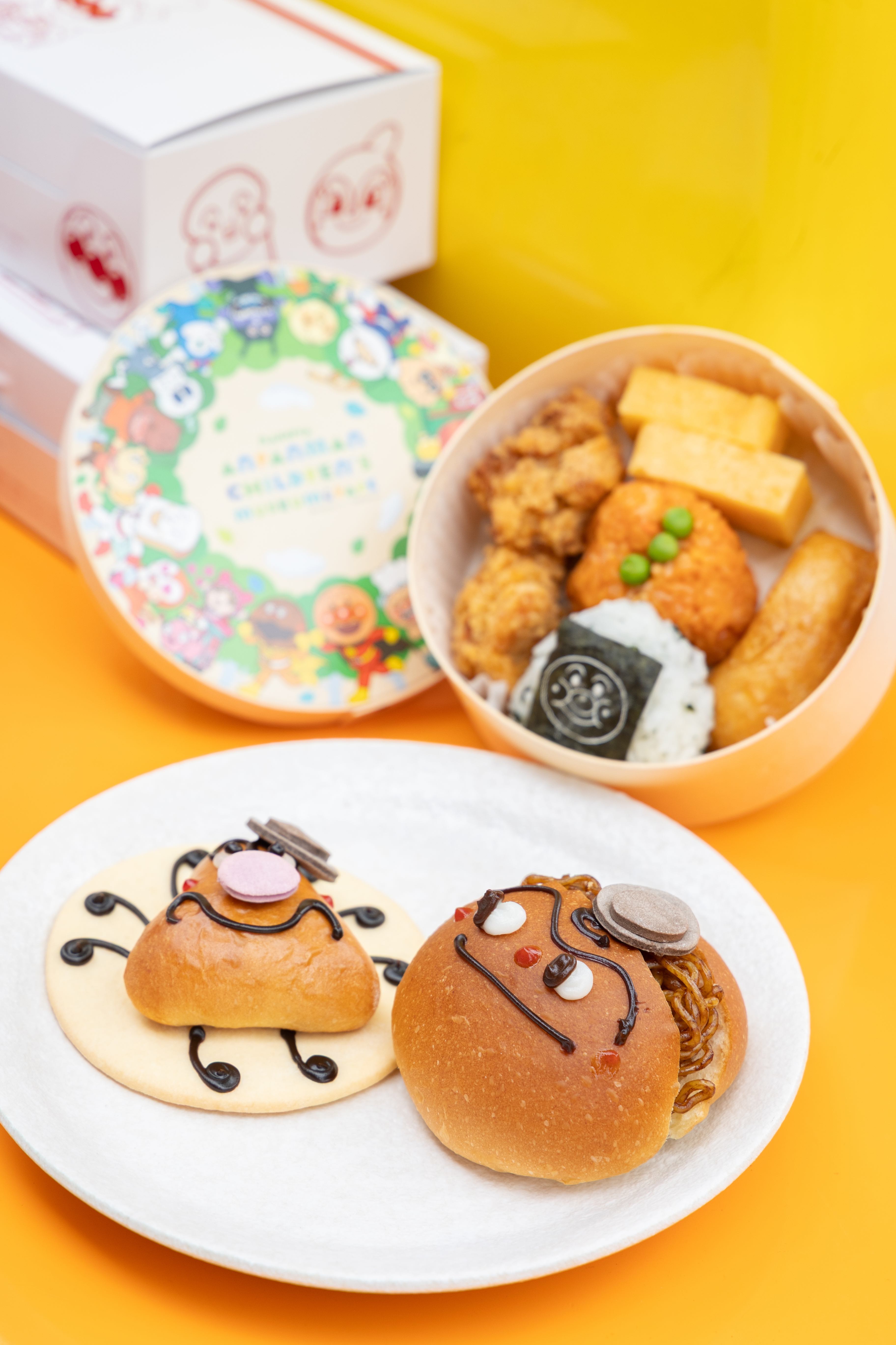名古屋限定便當「わっぱごはん」(後,1,250日圓起/個,約NT$243)、巧克力奶油口味的黴菌小鬼「かびるんるん」(前左,520日圓起/個,約NT$101)與炒麵麵包人「やきそばパンマン」(前右,520日圓起/個,約NT$101)。