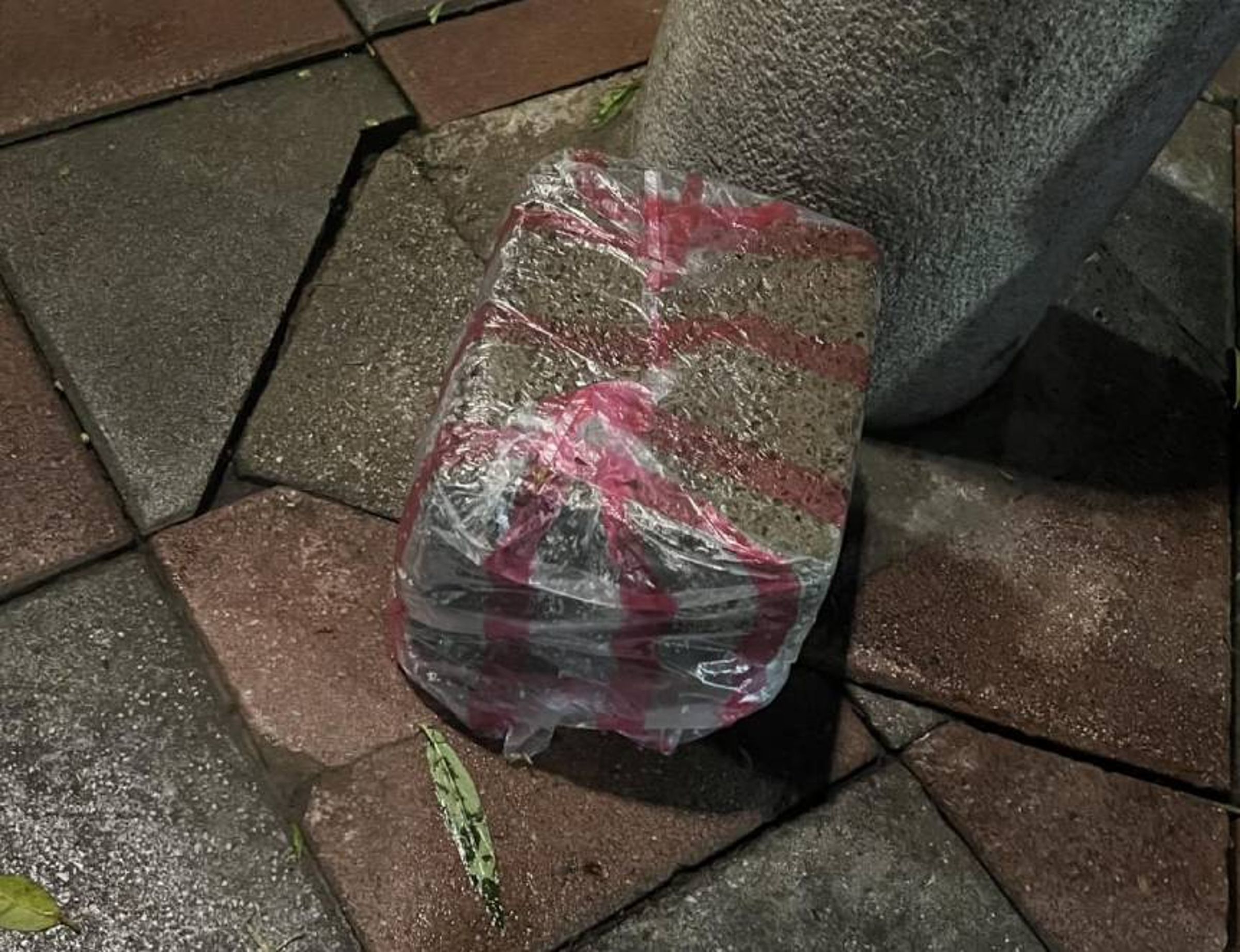 一名網友在路邊看到有塊大石頭被塑膠袋包住,讓他困惑不已提問「為什麼石頭要包塑膠袋?」。(翻攝自臉書「路上觀察學院」)