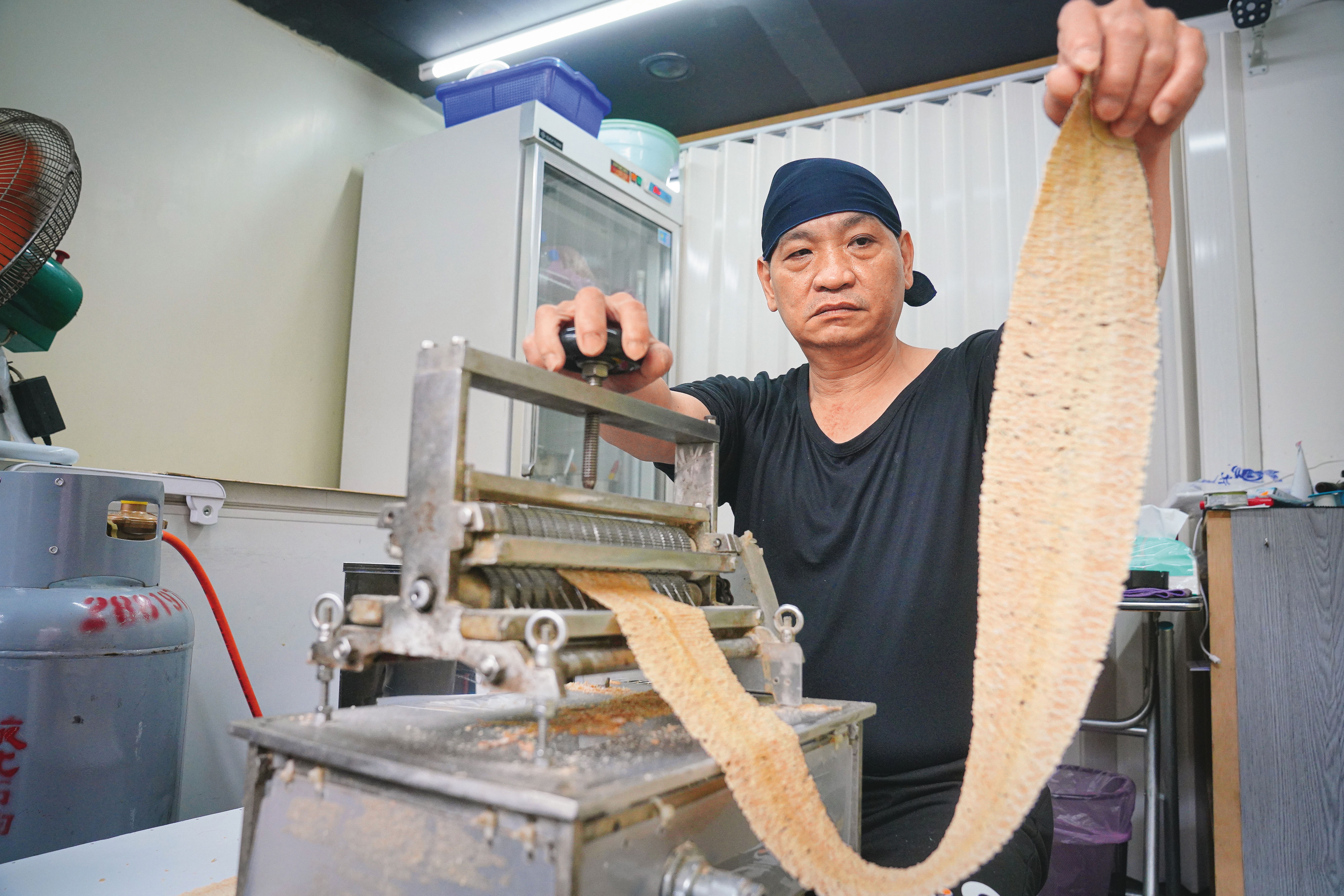 每隻魷魚只能壓成2片魷魚片，目前都由阿嬌姨的乾兒子小胖在開店前處理，雖以機器壓製，仍得靠手感微調，才能壓得均勻。