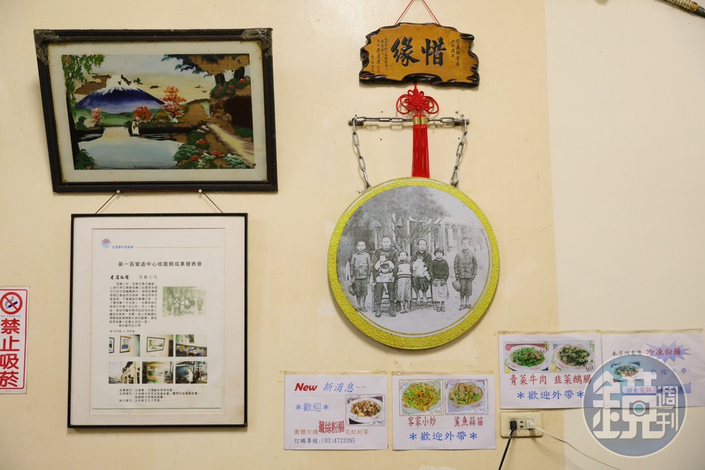 牆上除了日治時期留下的玻璃畫，也有著信義飲食店初代的家族合影。