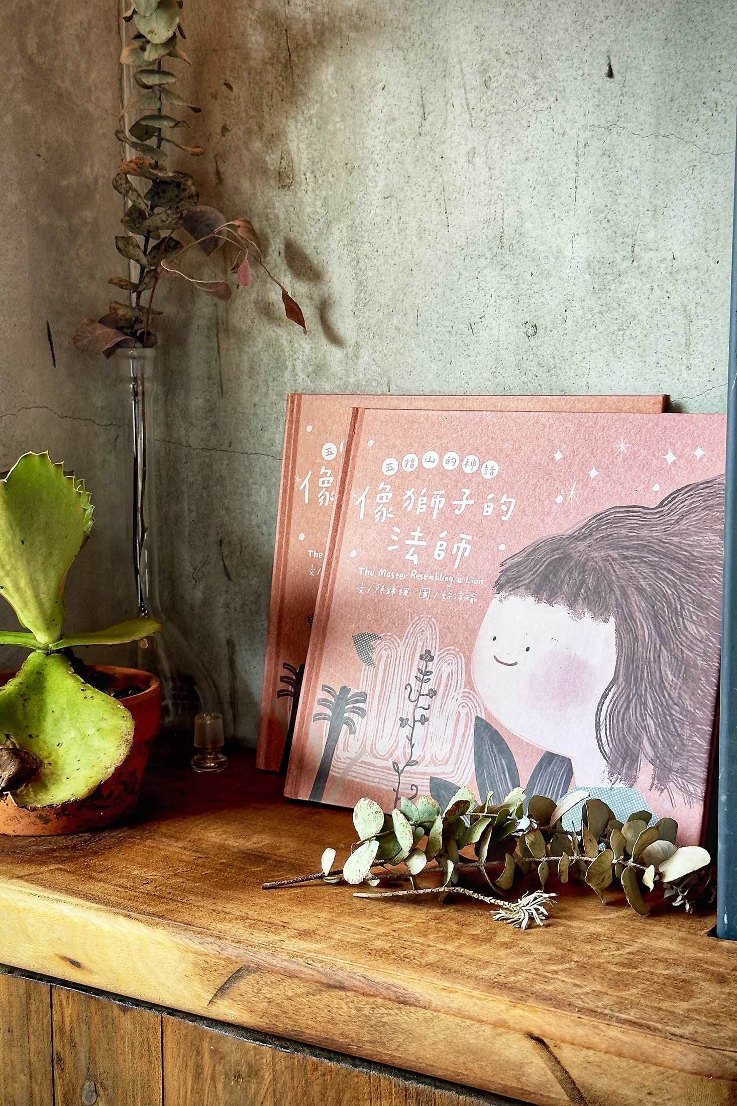 店裡除了擺設阿輝的陶藝作品、植栽布置，在書架上也能找到他與畫家一起創作的繪本。（童心怡攝）