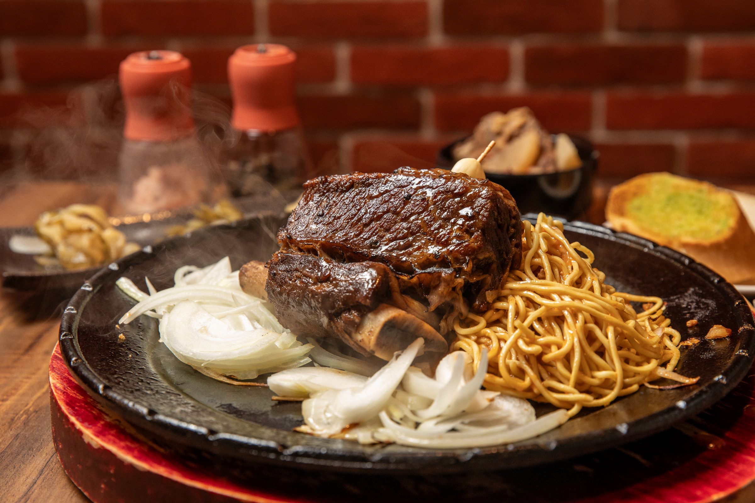 吃起來香氣十足、軟嫩的質骨牛排，是鬥炙詹厚德的最新力作，一客套餐單價 999元，不過他很有自信說不輸1590元台塑牛小排套餐。