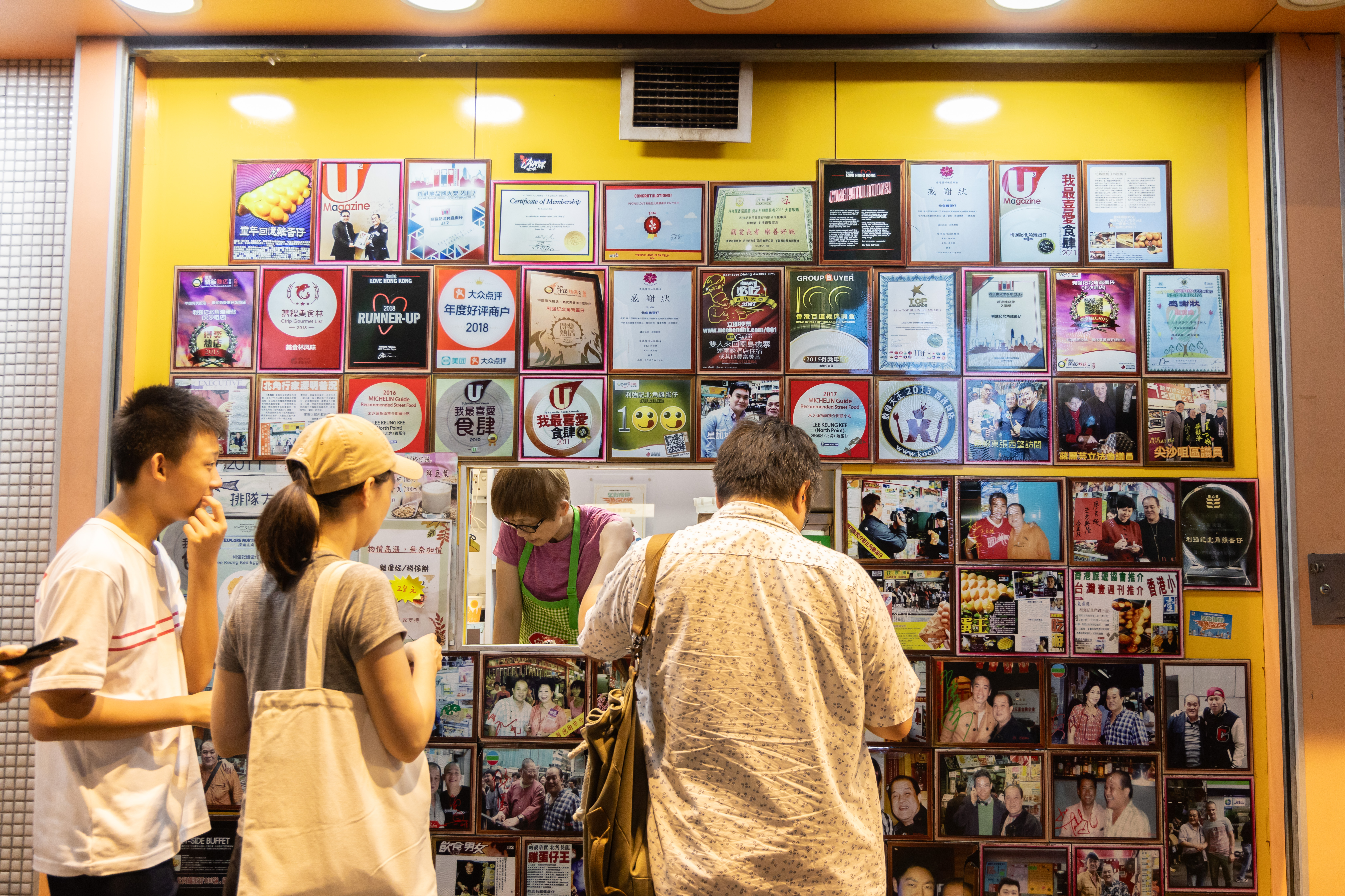 「利強記」的窗口四周貼滿報導與名人照片，可見其在雞蛋仔界的江湖霸主地位。