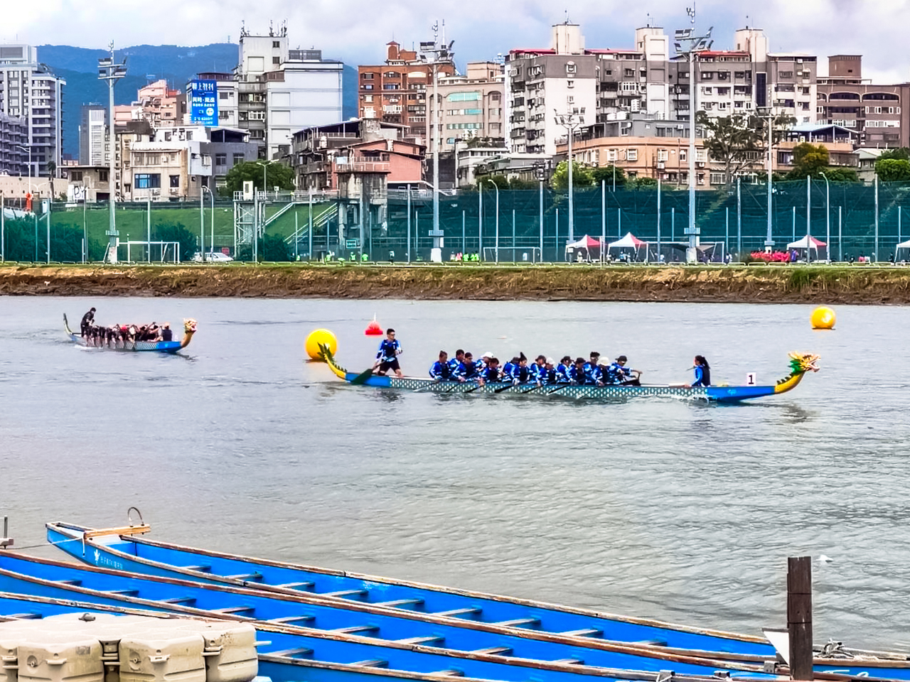 第21屆鯨神盃龍舟錦標賽總計65支隊伍在百齡橋下左岸河濱公園齊聚競技，場面熱血沸騰。（永慶房產集團提供）