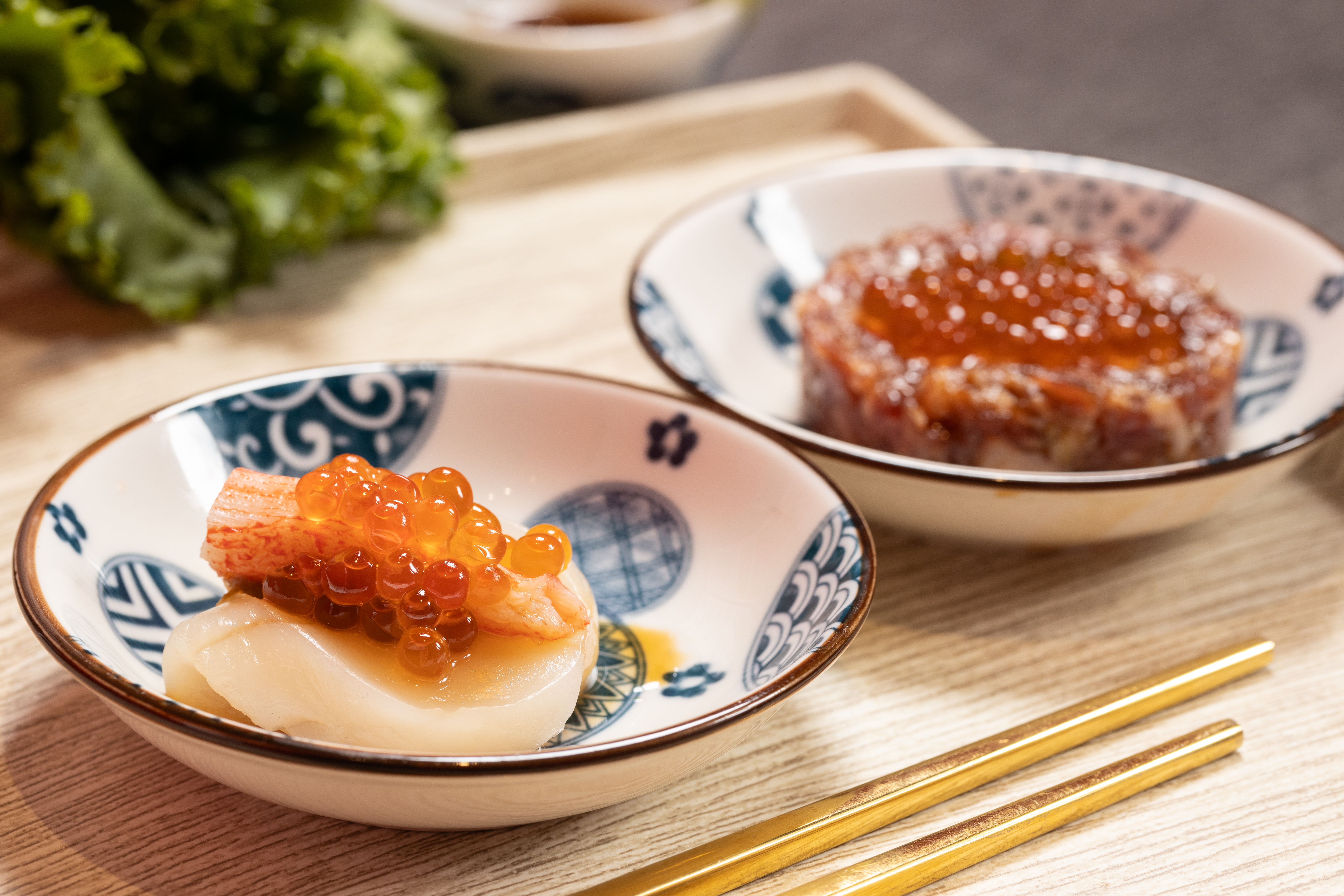 「招牌生食干貝漢堡」把北海道干貝夾入松葉蟹膏和蟳味棒，再澆淋鮭魚卵，一口吃，鮮味洶湧。（189元／份，圖左）