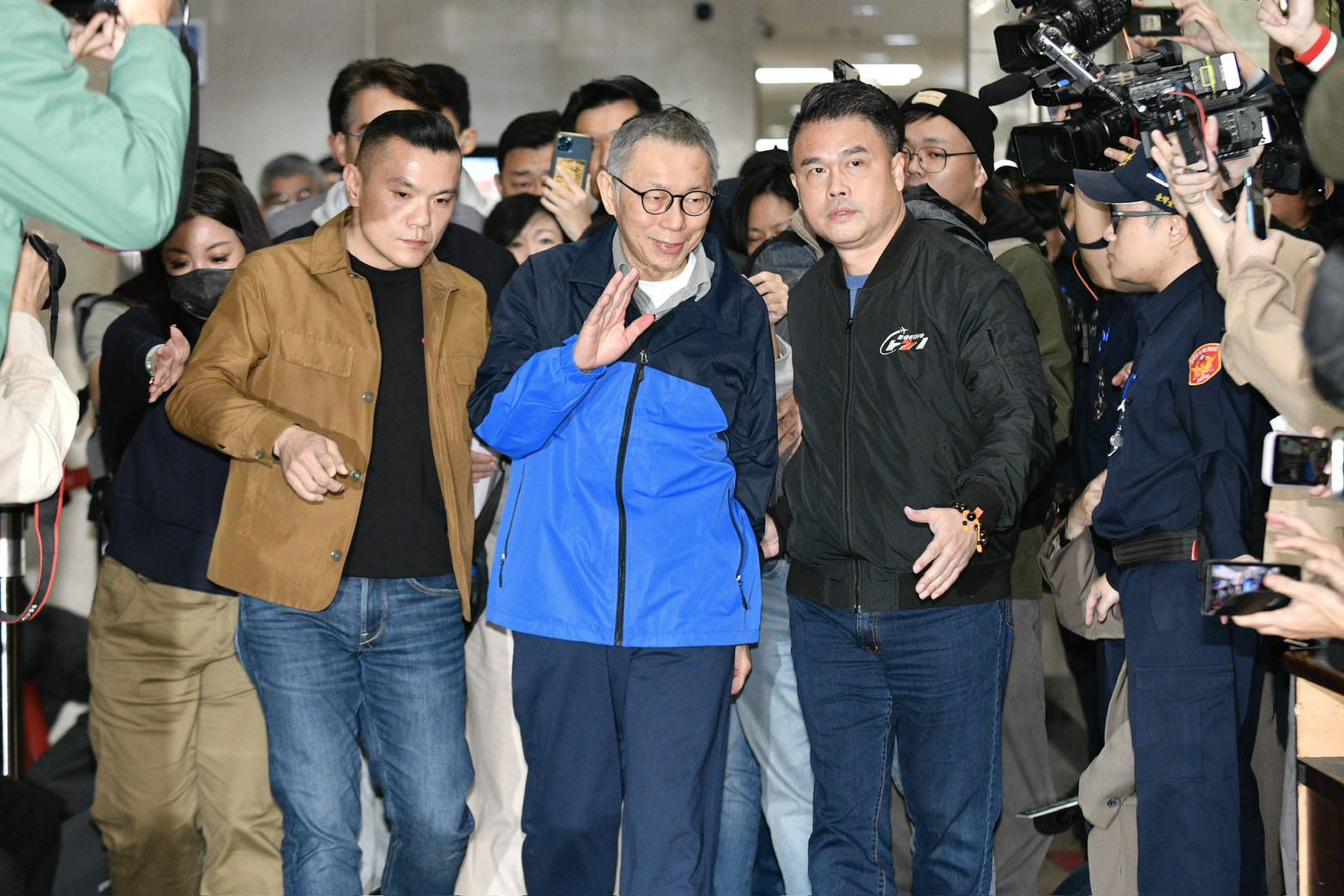 柯文哲在媒體簇擁下笑著走出地院。