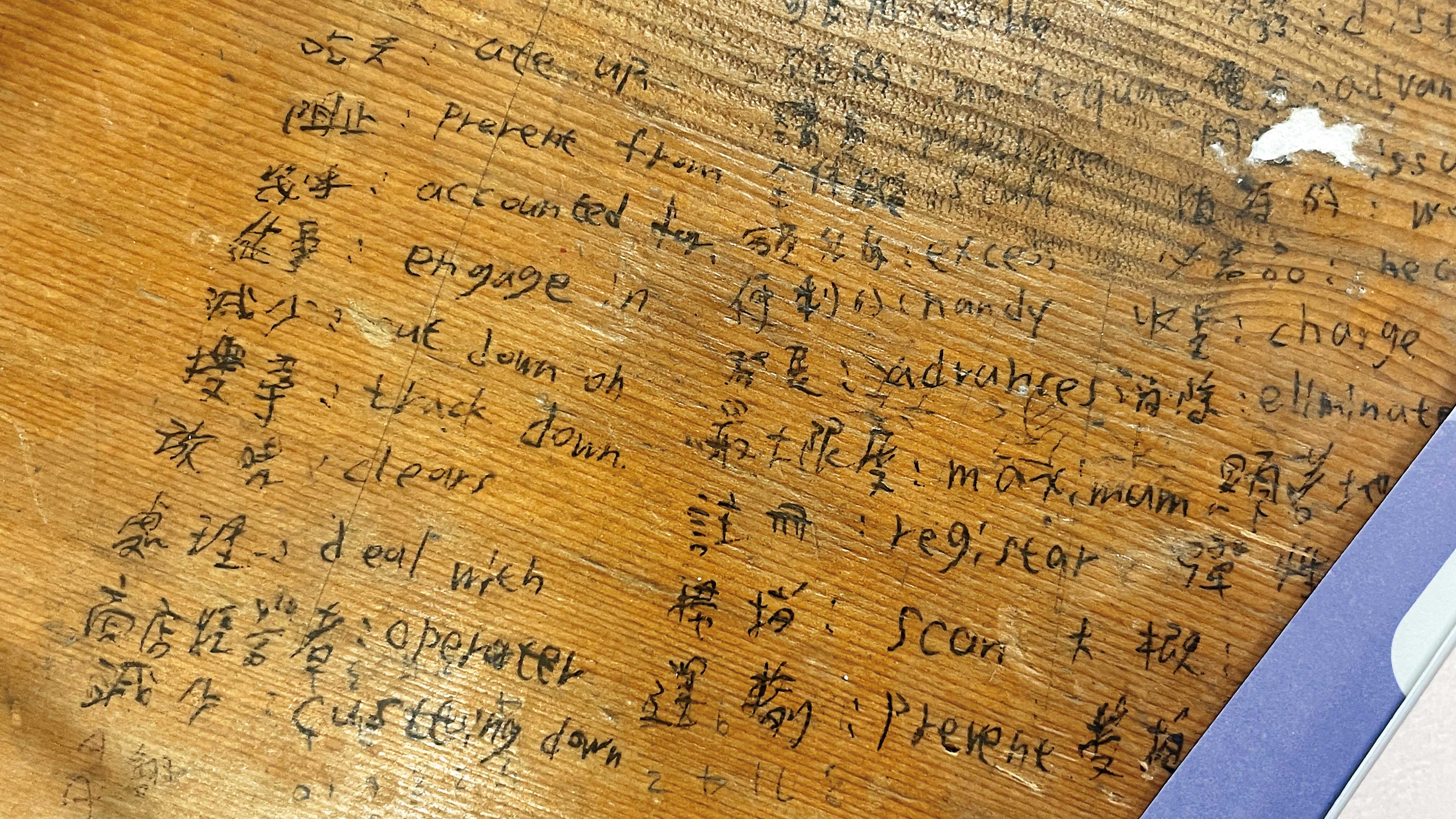 教室桌上的「小抄」相當明顯，但監考老師卻裝瞎當沒看見。（讀者提供）