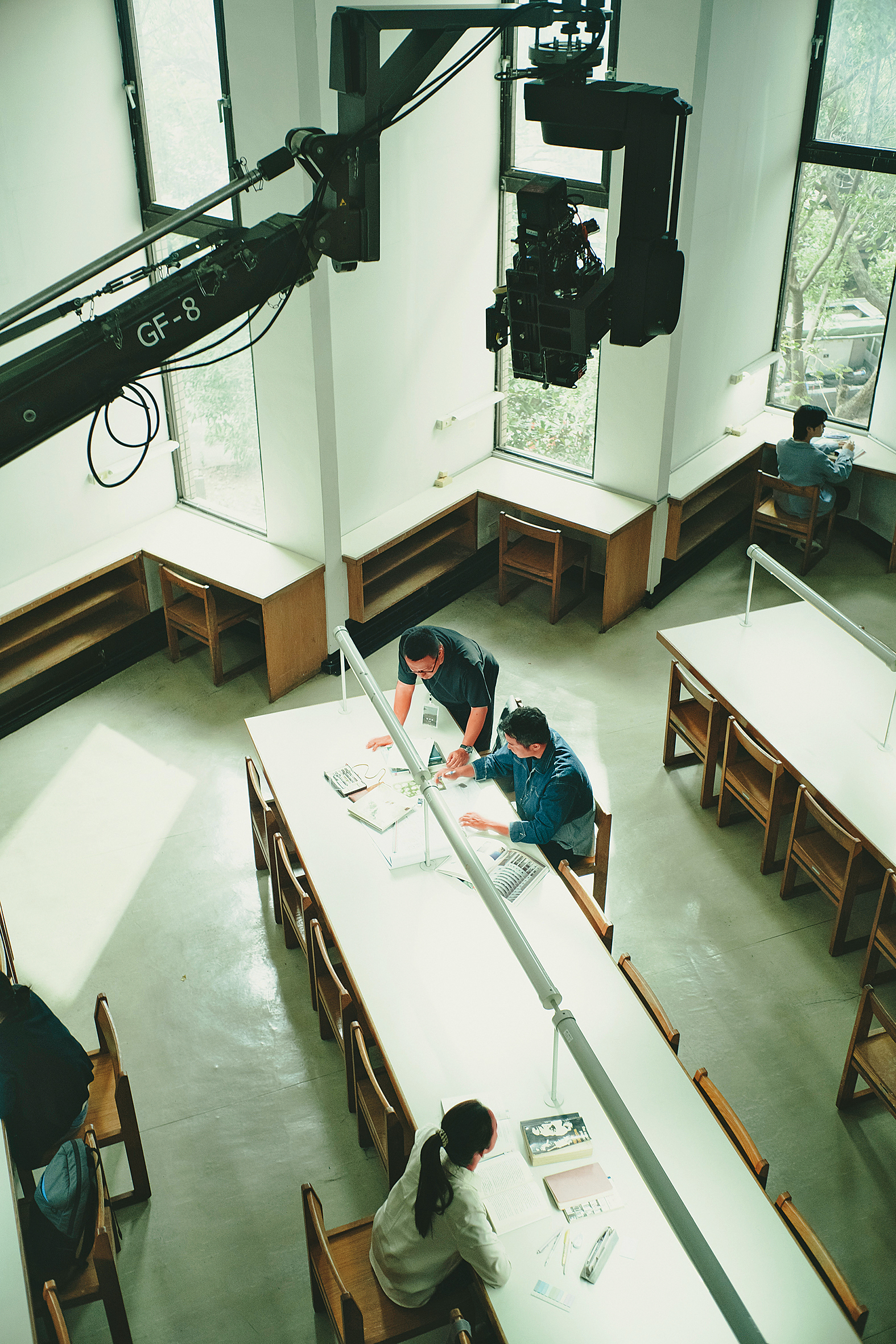 電影第一場戲在政大圖書館拍攝，導演沈可尚（上）與演員張孝全（中）、林依晨（下）溝通討論。（風起娛樂提供）
