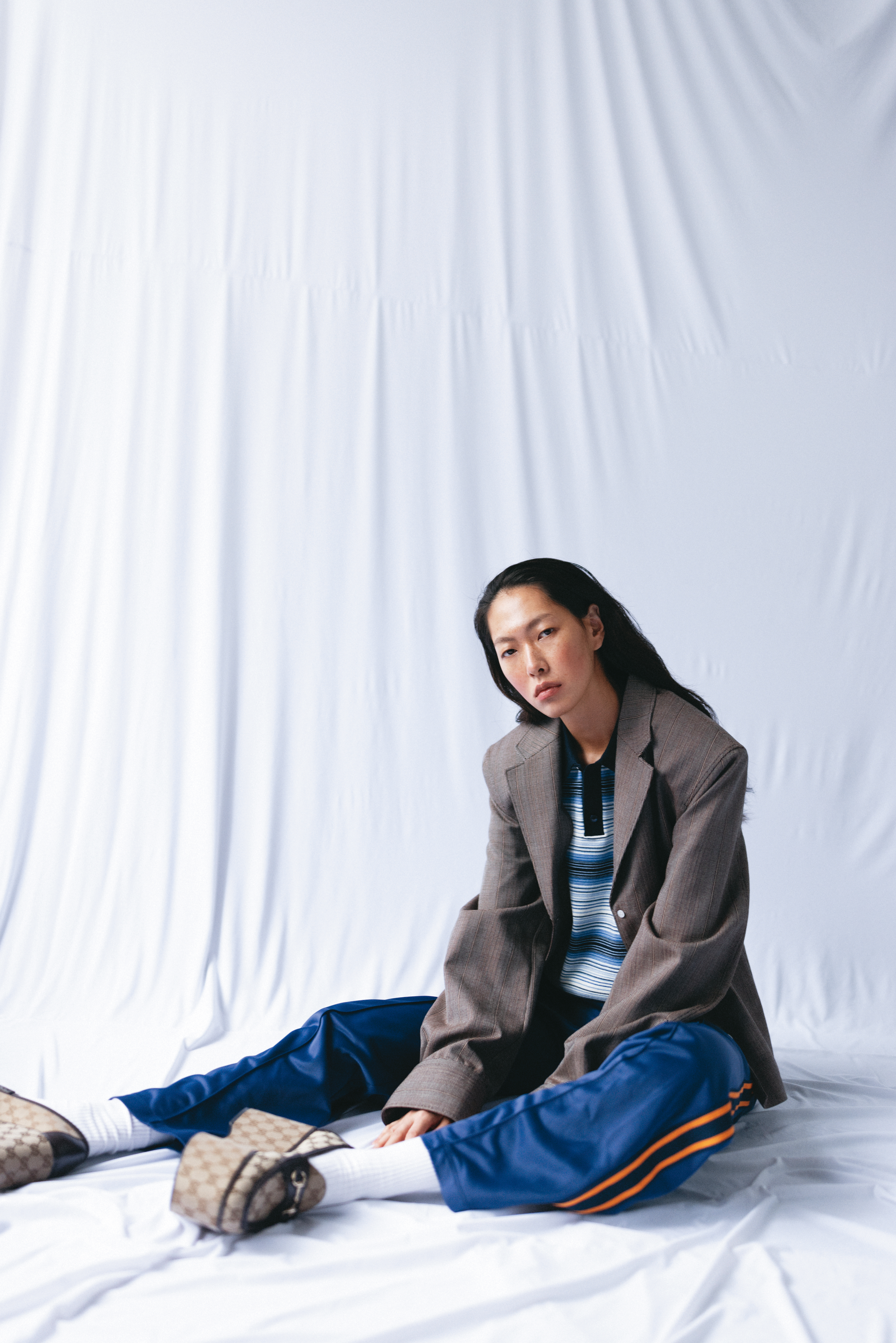 棕色西裝外套 價格店洽 by PRADA／條紋短款上衣 價格店洽 by CELINE BY HEDI SLIMANE／復古海軍藍運動長褲 NT$40,500 by CELINE BY HEDI SLIMAN／logo厚底樂福鞋 NT$46,300 by GUCCI