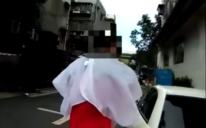 頭髮剪一半的「白巾人」突然從髮廊衝出，強硬把車開走，撞傷一旁要開單取締的員警。（翻攝畫面）