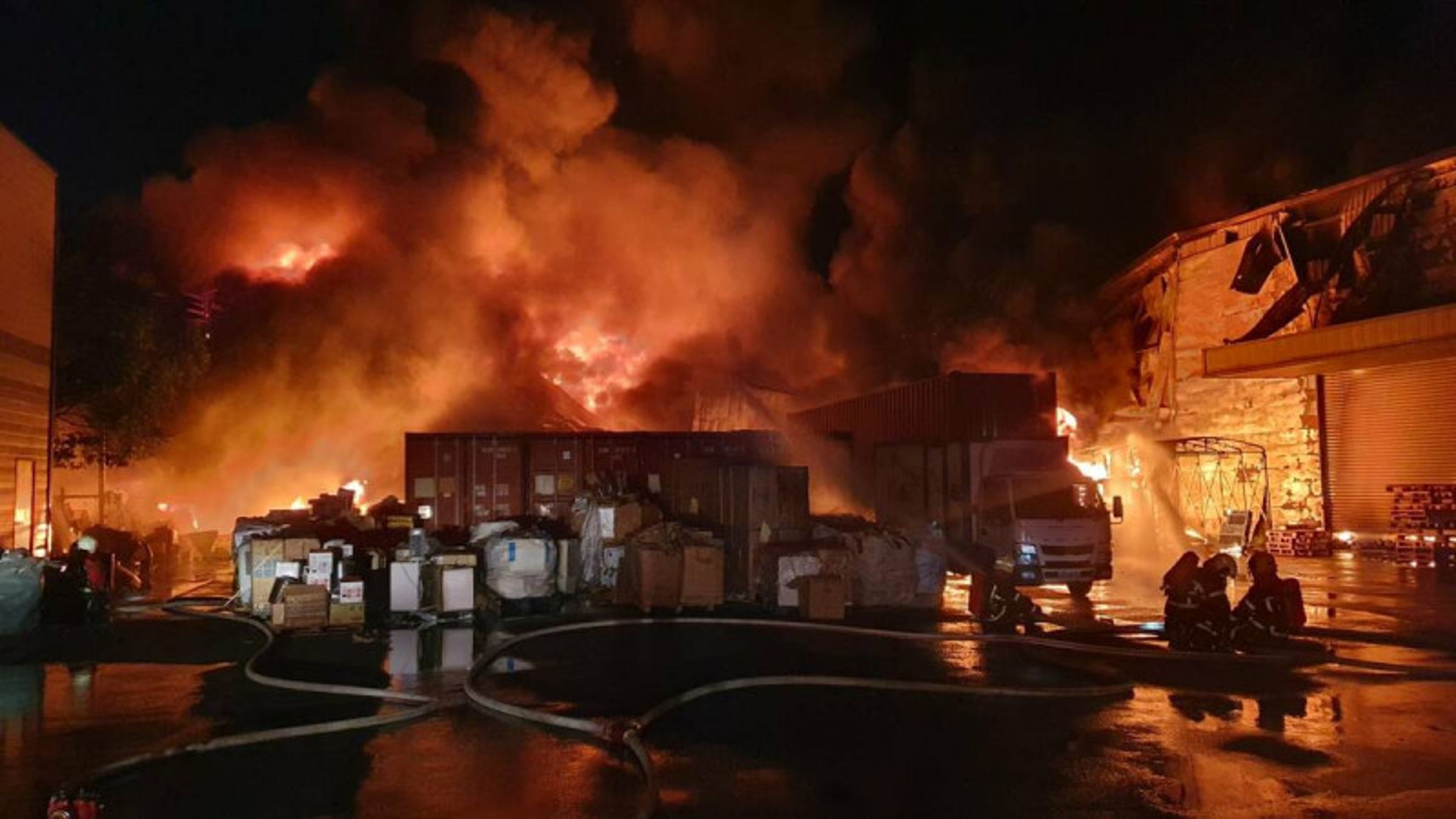 屏東縣萬丹鄉「大家源家電」倉庫昨(23日)發生火大,烈焰竄天。(屏東縣消防局提供)