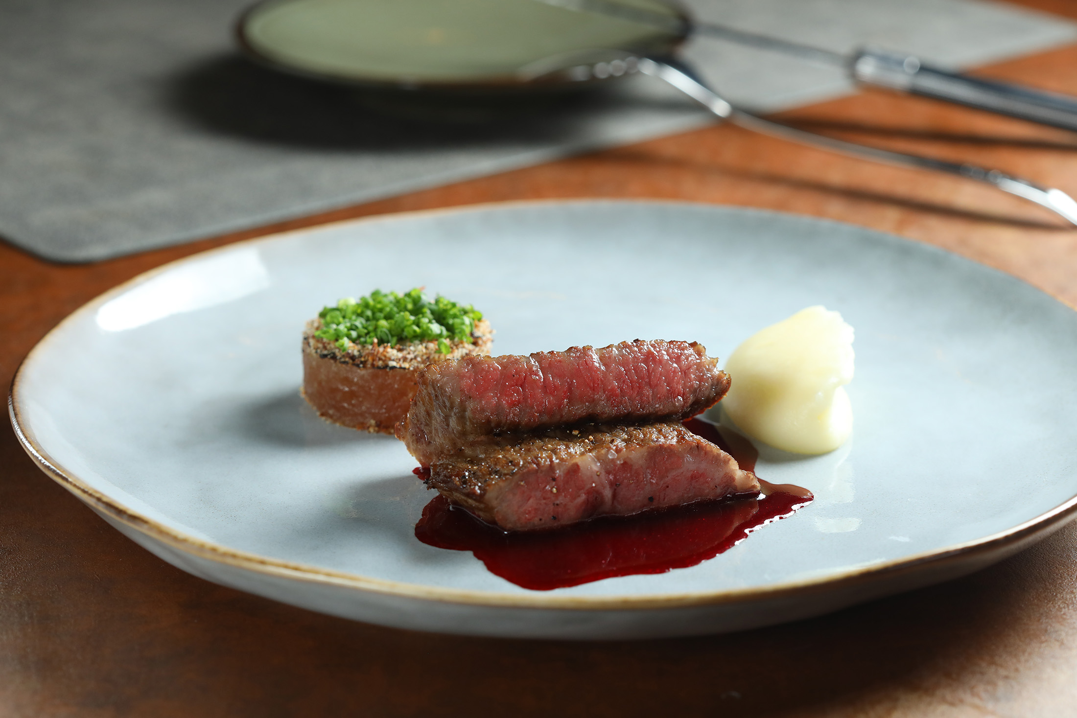 「直火1954 Bar & Grill」主廚利用油煎與炭火，讓「A5和牛、甜菜、粉紅胡椒」的牛肉口感細膩，油脂豐腴。（1,800元套餐主菜）