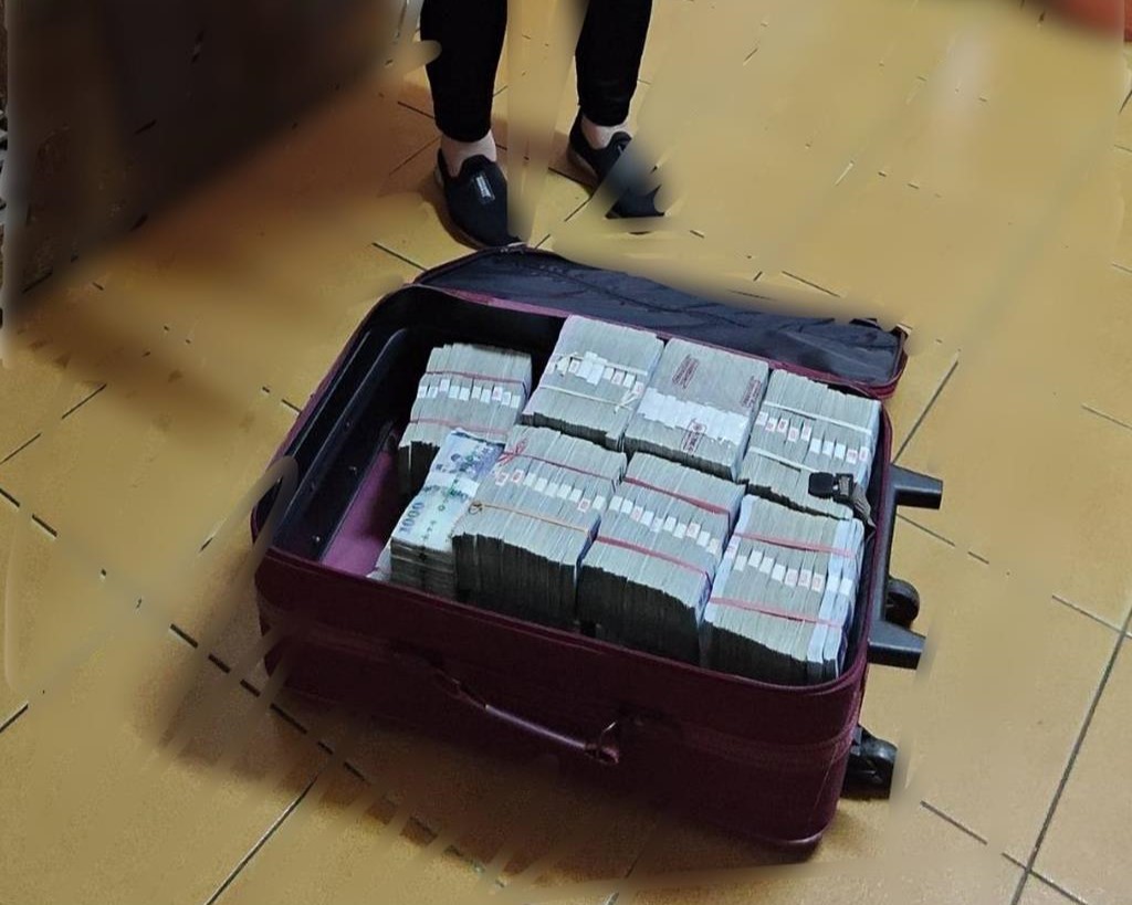 台中一名醫師拖著裝滿現金的行李箱要與詐團面交，所幸警察及時阻止。（翻攝畫面）