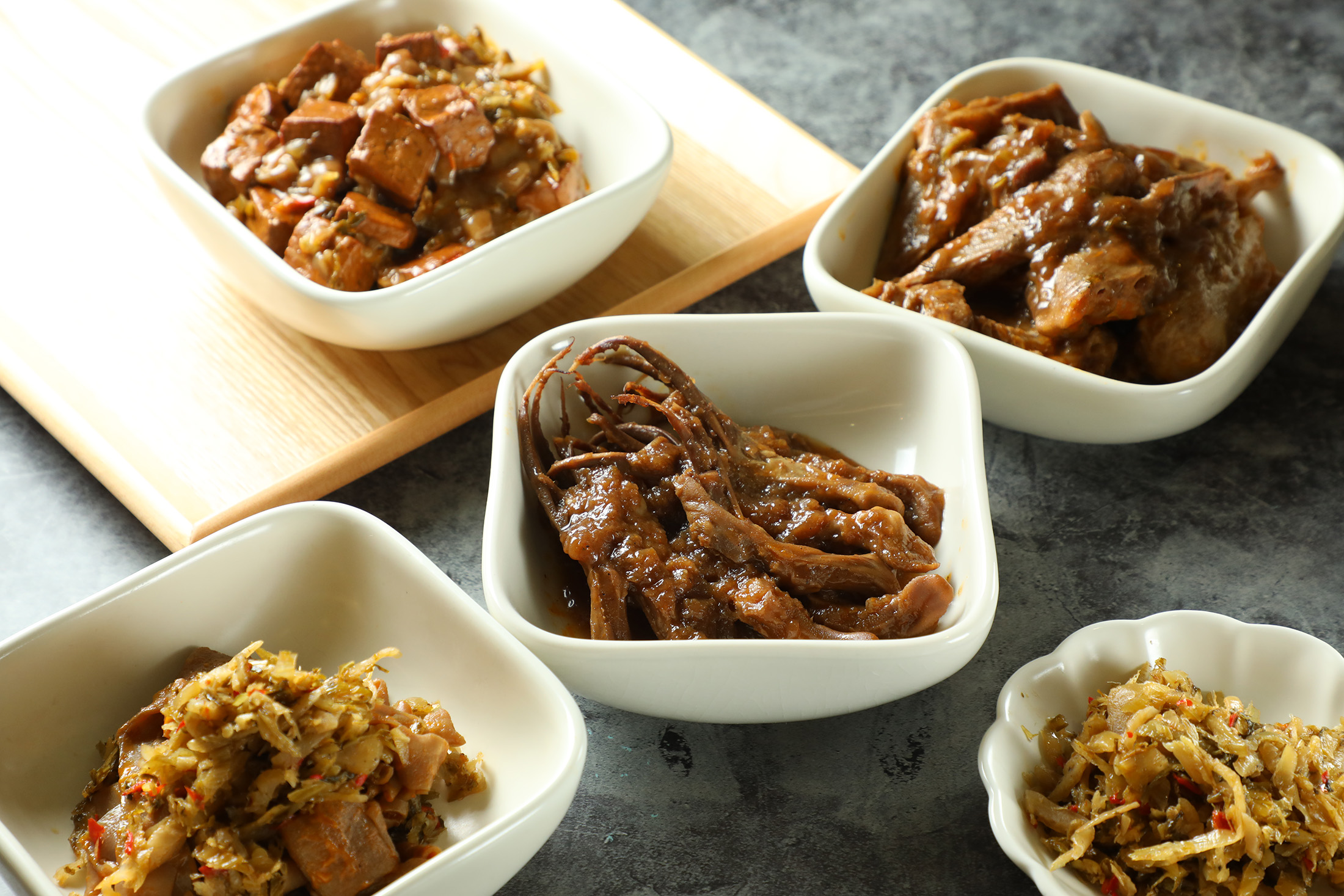 使用牛尾湯汁滷製的「豆干」（左起逆時針，110元／份）與「鴨舌」「鴨翅」「鴨腸」（皆250元／份），是店內最受歡迎的小菜。