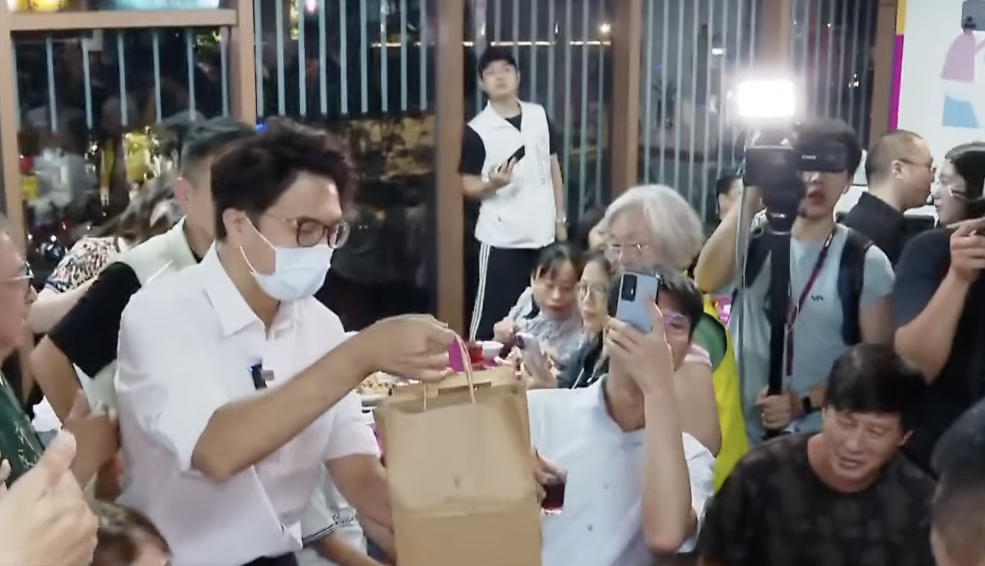 徐男這次現身南門市場,送上自己親手烘焙的咖啡豆給沈伯洋當禮物。(鏡新聞)