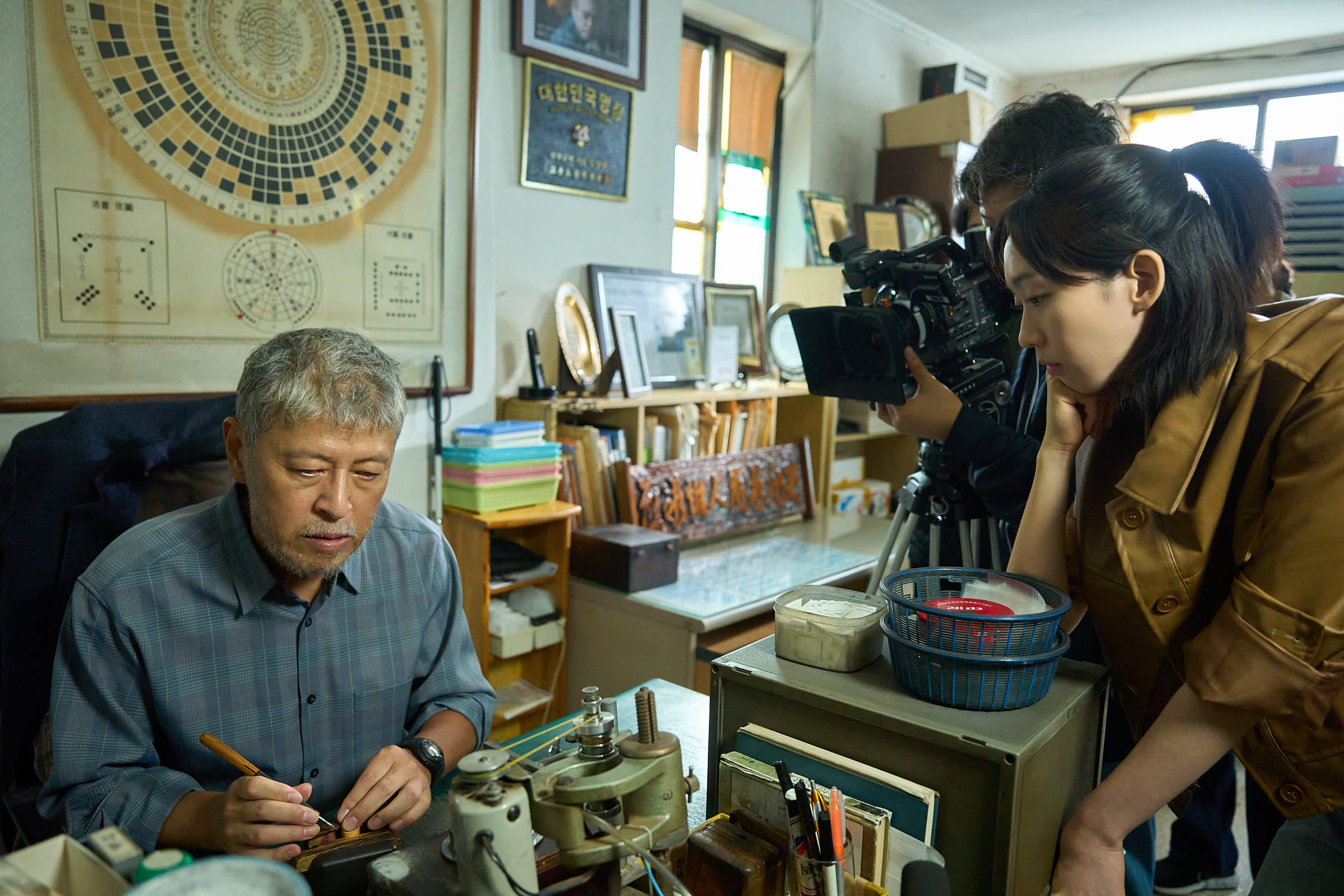 權海驍（左）在《醜得要命》飾演天生失明的篆刻師，吸引電視節目導演韓智賢邀訪。（壹壹喜喜提供）© 2025 Plus M Entertainment and WOWPOINT. All Rights Reserved.