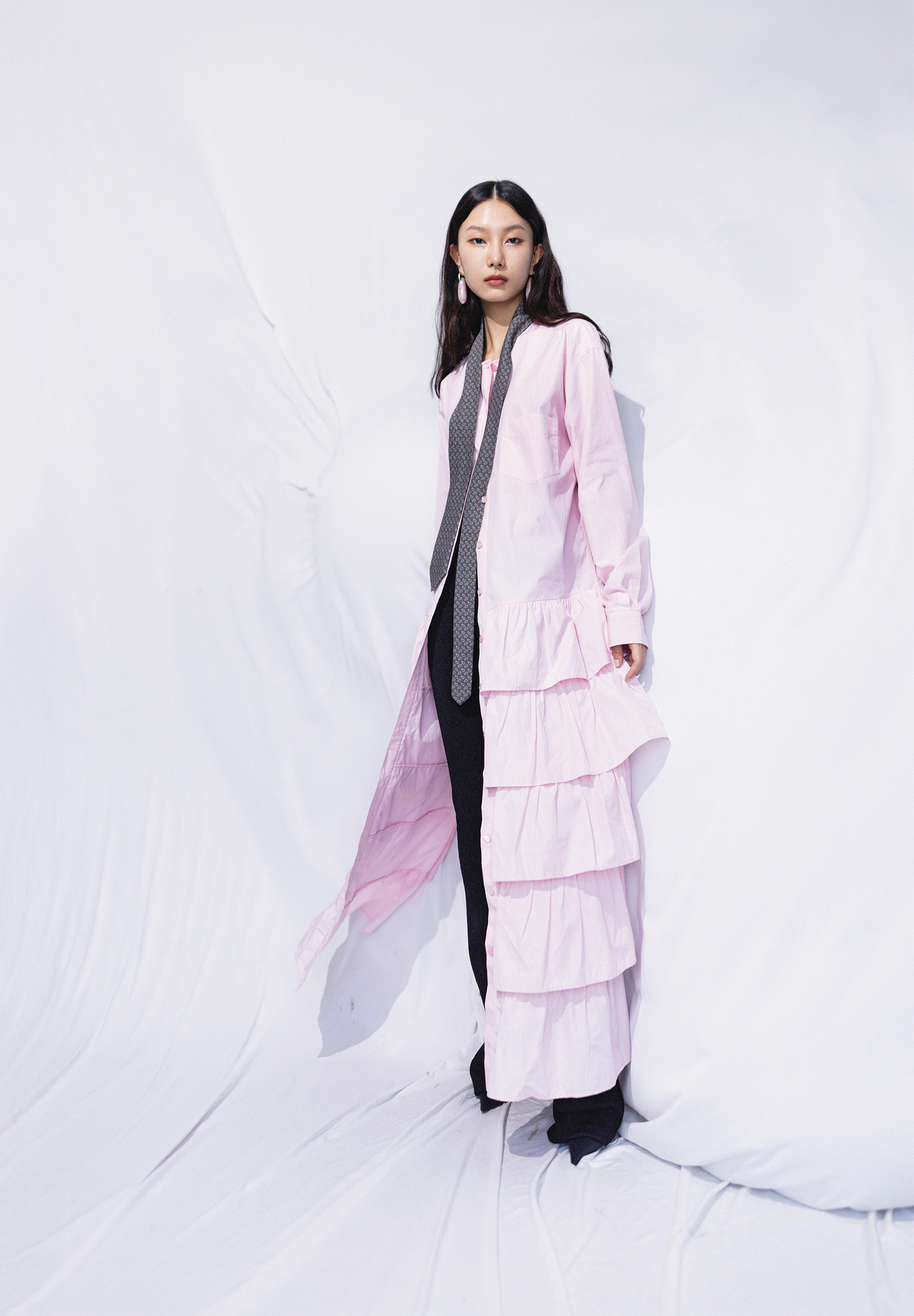 粉色蛋糕裙洋裝NT$79,800 by MOSCHINO／黑色針織合身長褲NT$71,000 by PRADA／尖頭短靴NT$43,200 by BALENCIAGA／純銀鍍金琺瑯造型耳環 價格店洽by BOTTEGA VENETA