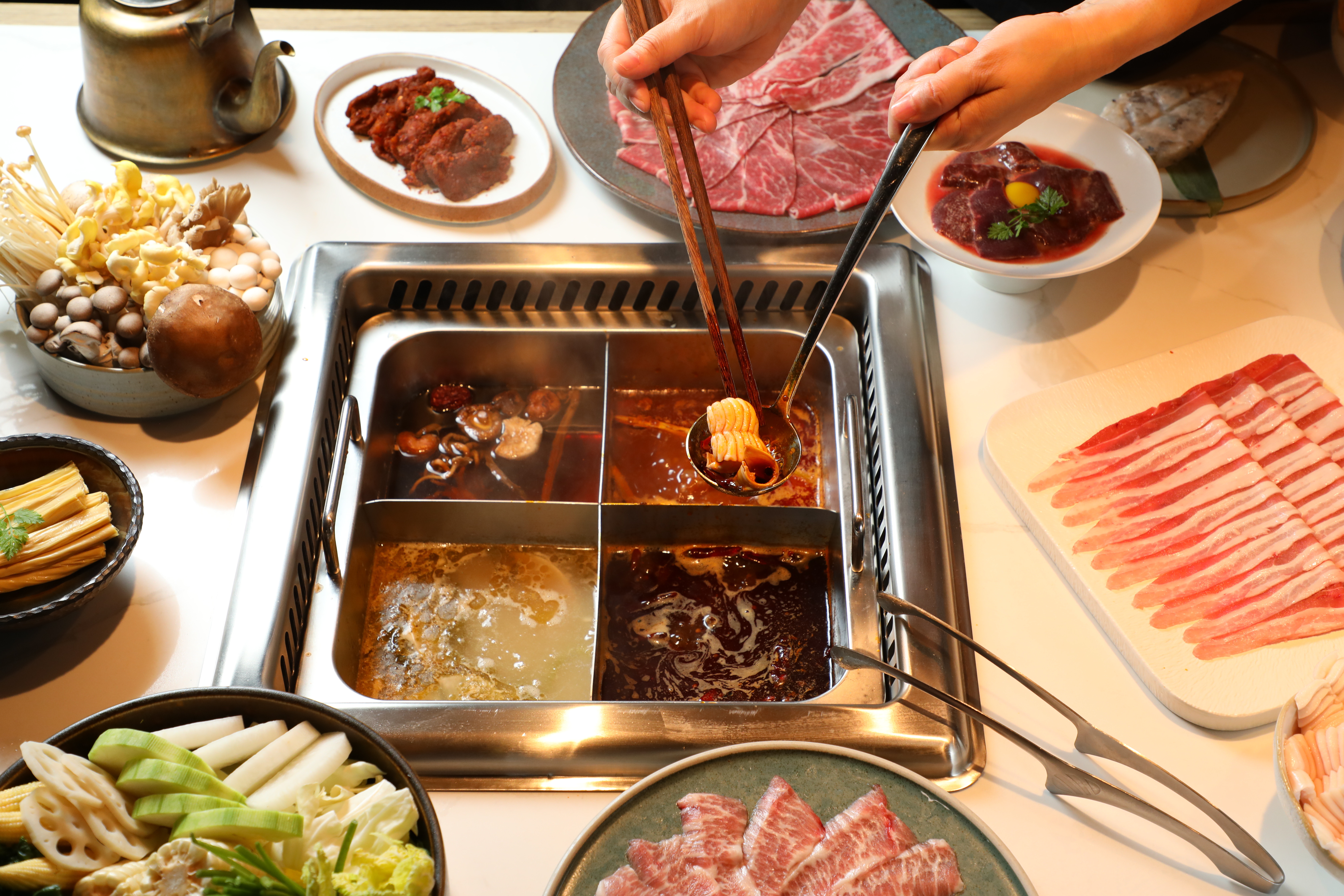 2023年12月底新開張的「重慶火鍋緋花」,主打道地的牛油火鍋,以四宮格方式呈現,可同時吃到酸菜魚鍋等口味。