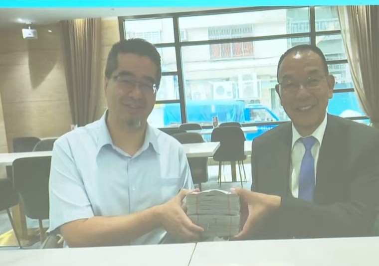 金溥聰秀出蕭旭岑收台商捐款時雙方燦笑合影畫面。(鏡新聞提供)