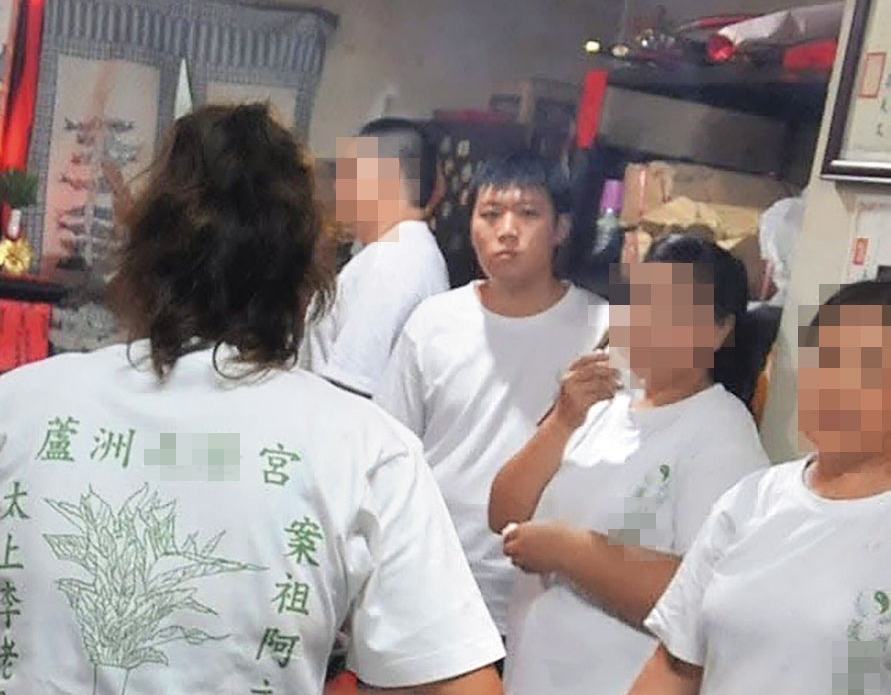 廖聰賢(箭頭處)曾與父親一同參加宮廟活動,留下唯一的正面照。(翻攝畫面)