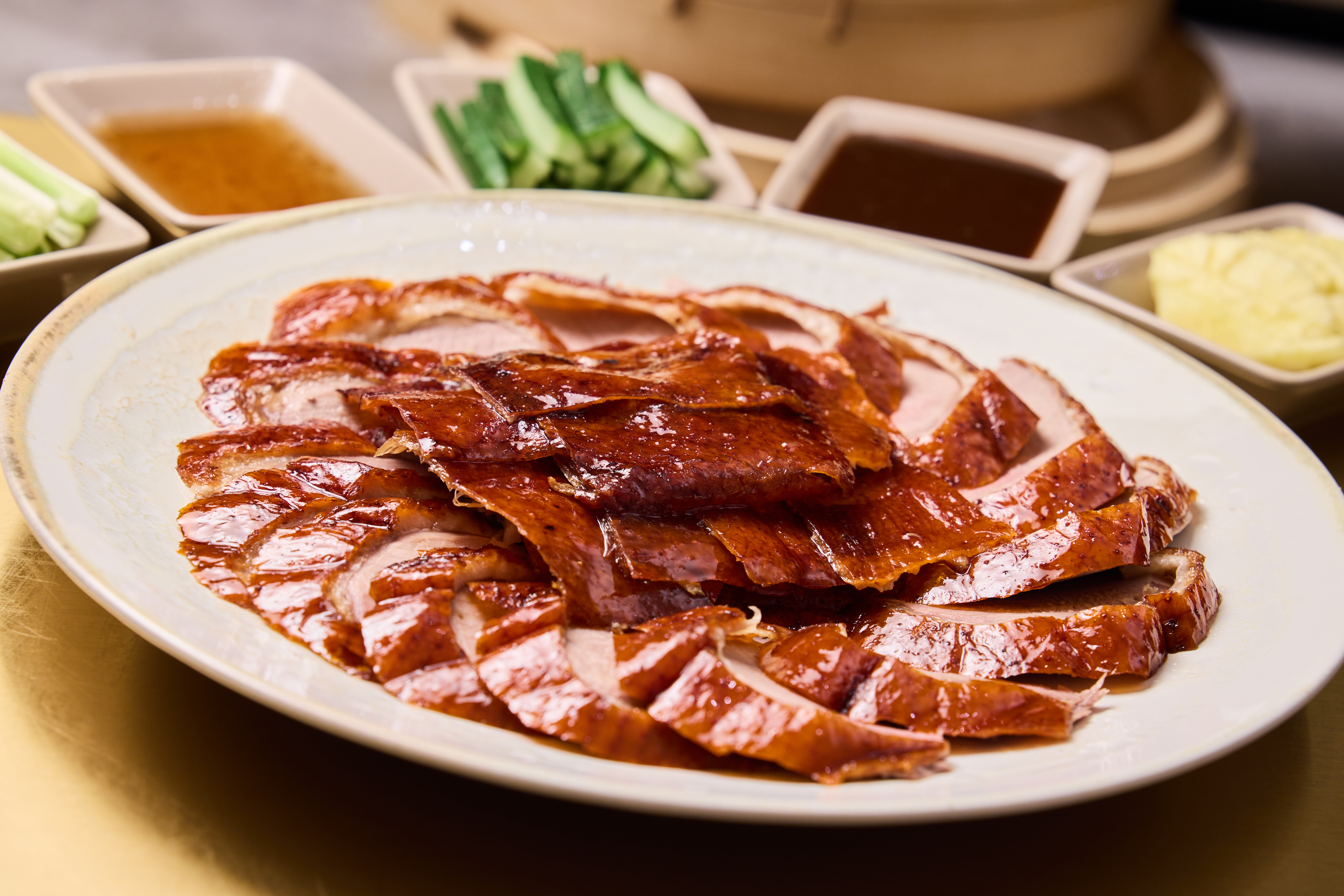 「經典片皮鴨」切片油亮上桌,皮香肉嫩,搭配沾醬與配菜更添層次。