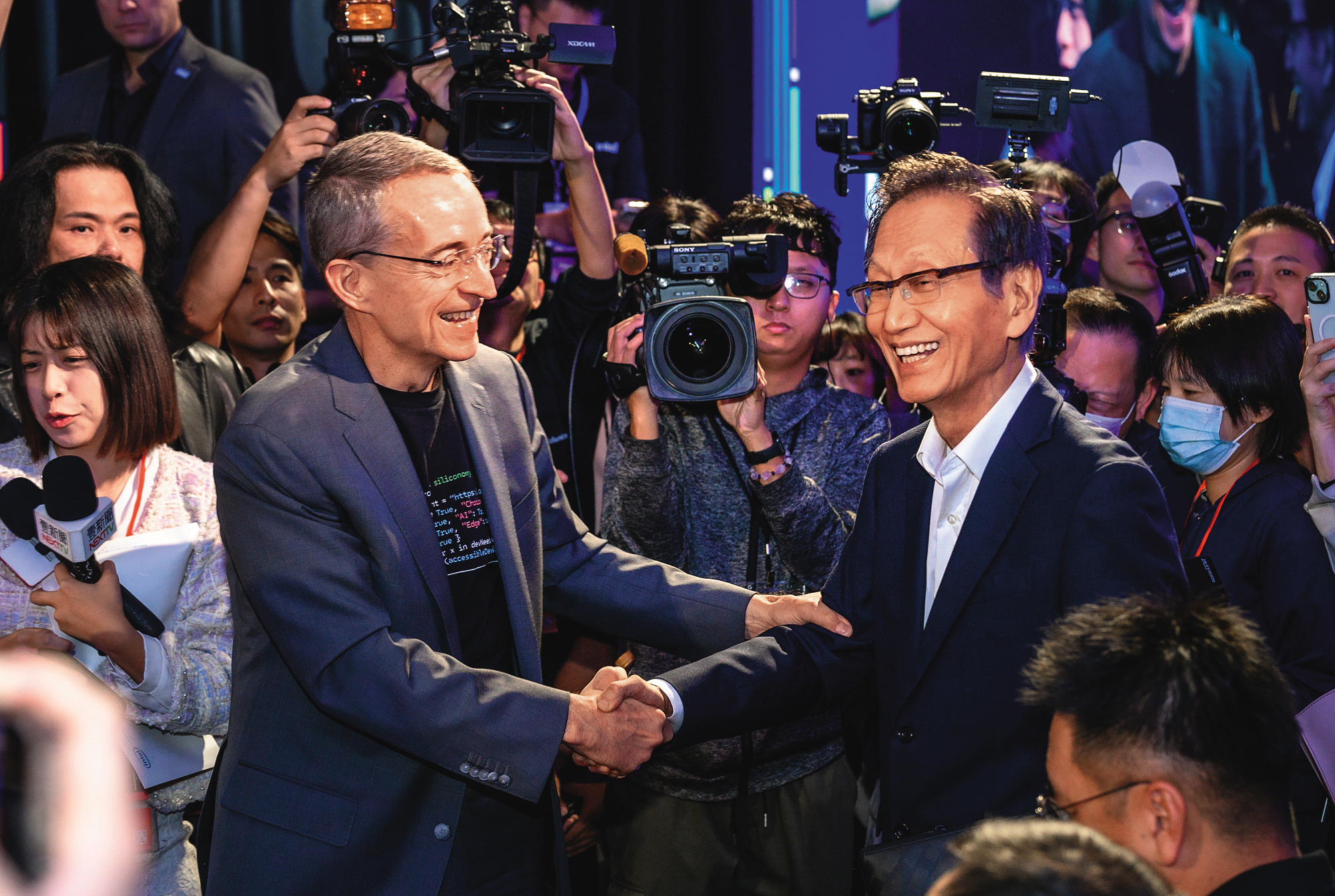 英特爾執行長季辛格（左）請華碩董事長施崇棠（右）展示英特爾在AI PC的應用。